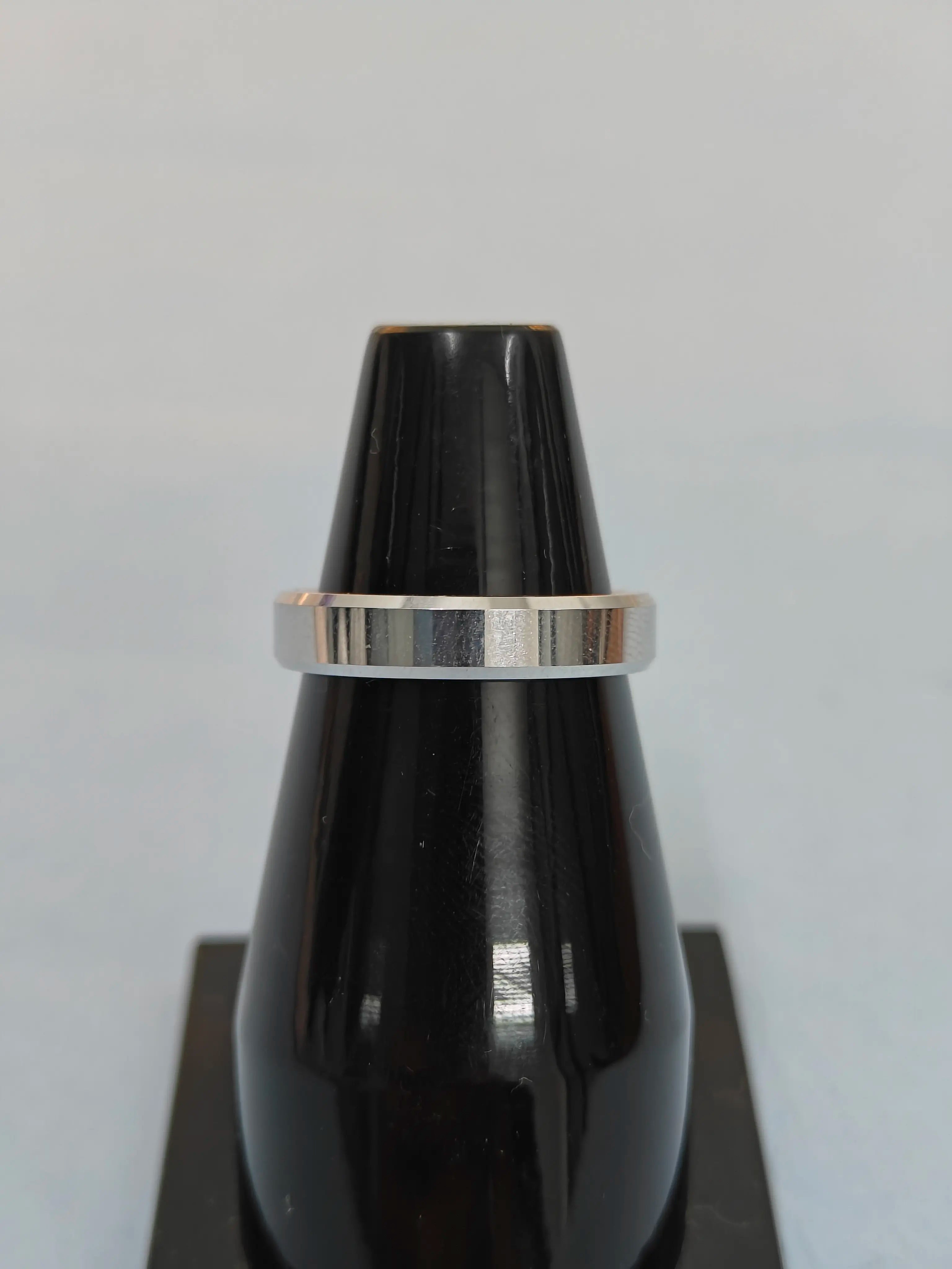 Black vase with a silver band on a light gray background