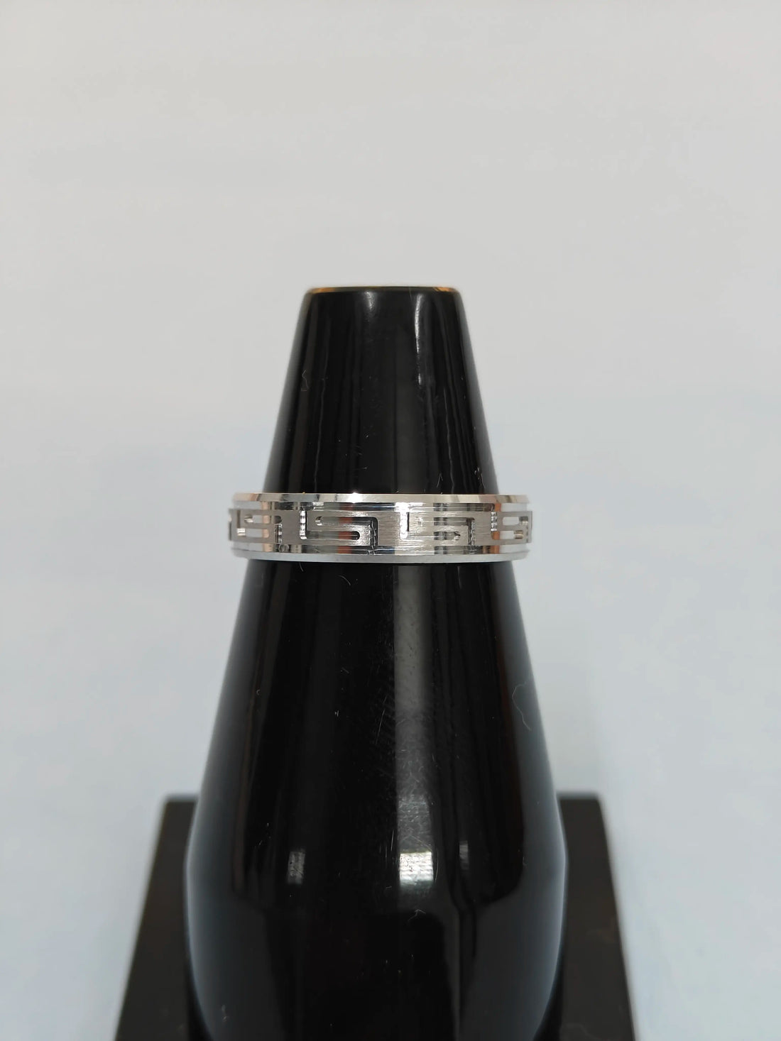 Black lacquer vase with a silver band on a white background