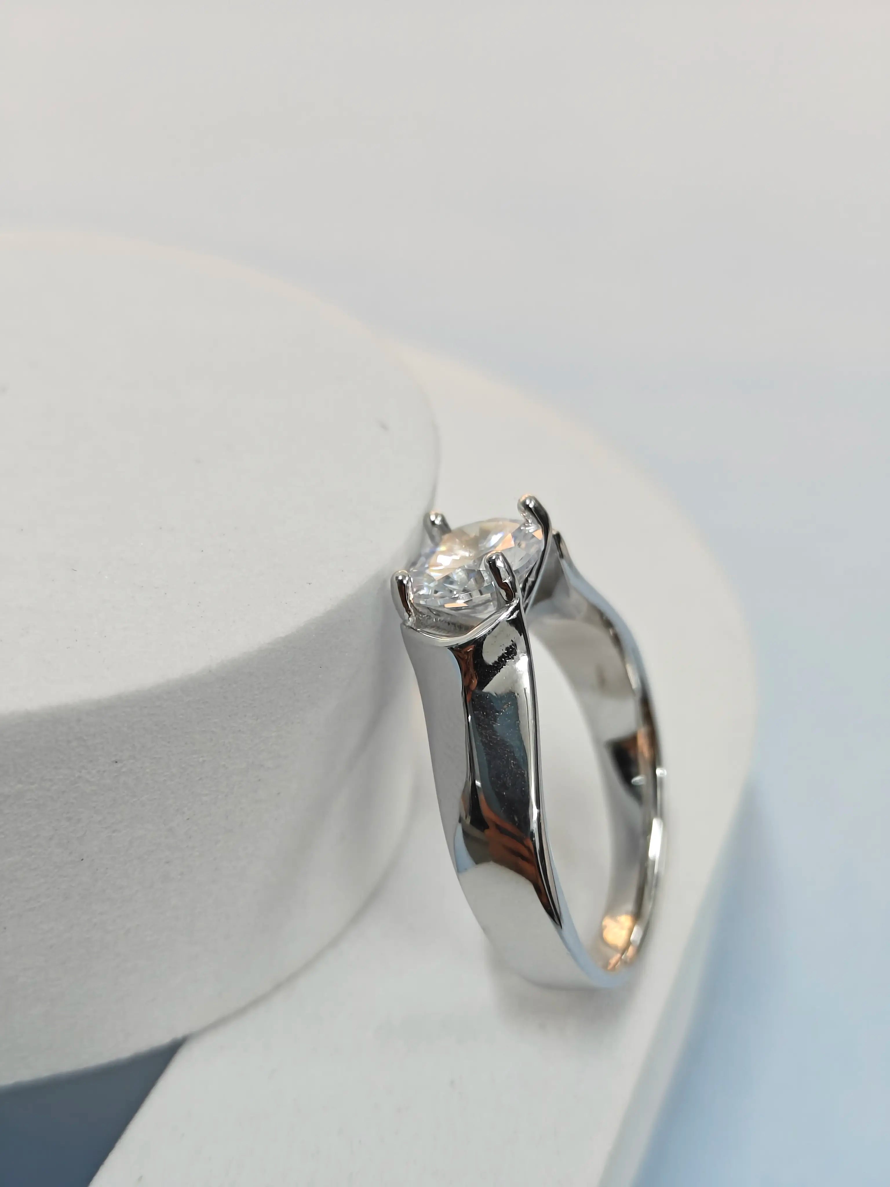 Silver earring with a clear gemstone on a white background