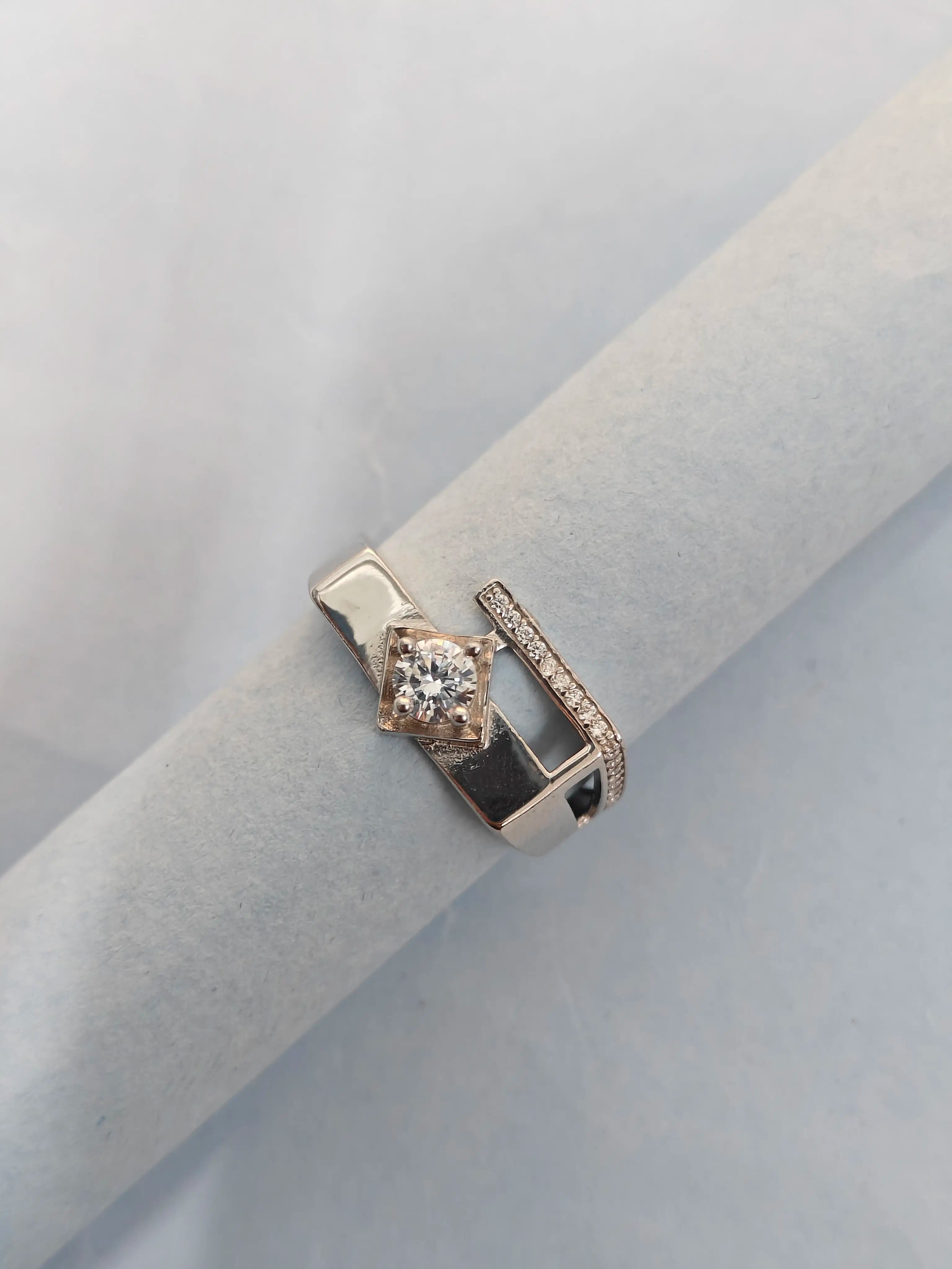 Rose gold ring with a diamond on a light gray background