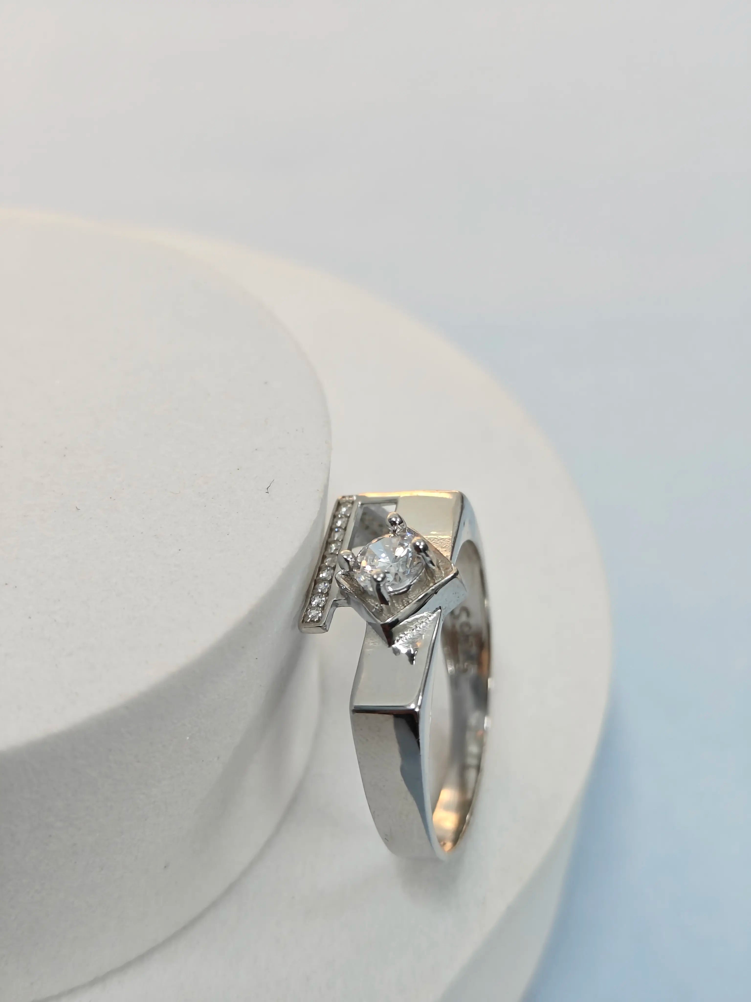 Silver ring with a diamond on a white background