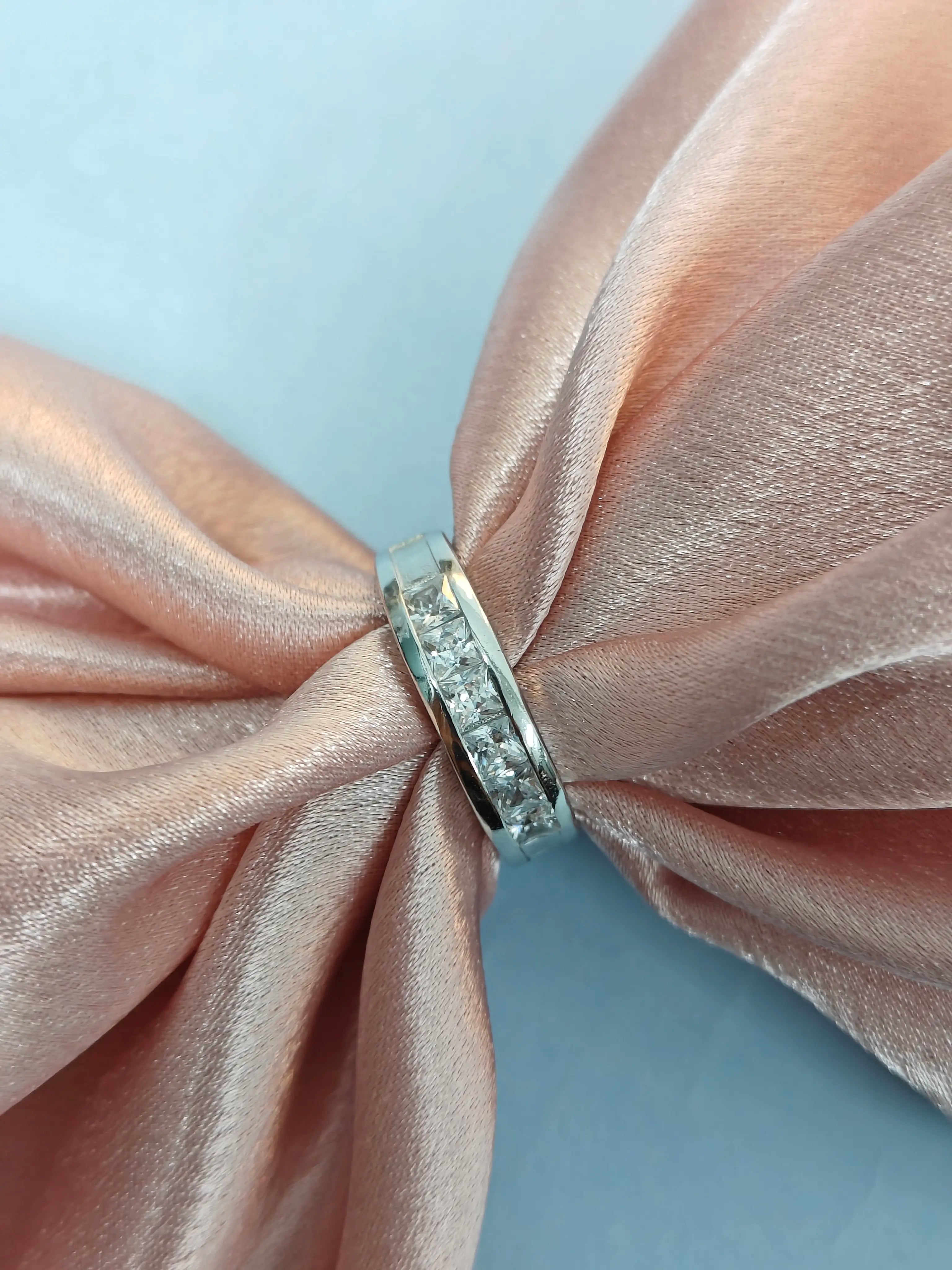 Silver ring with small diamonds on a pink satin bow