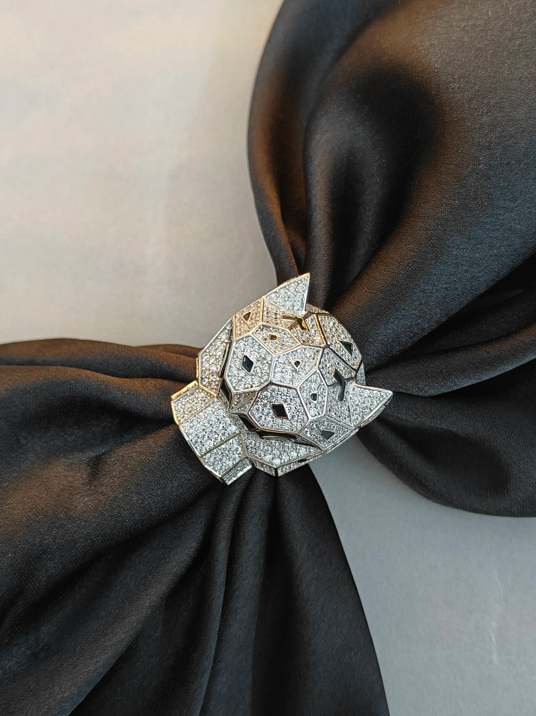 Diamond-encrusted brooch on a black fabric background