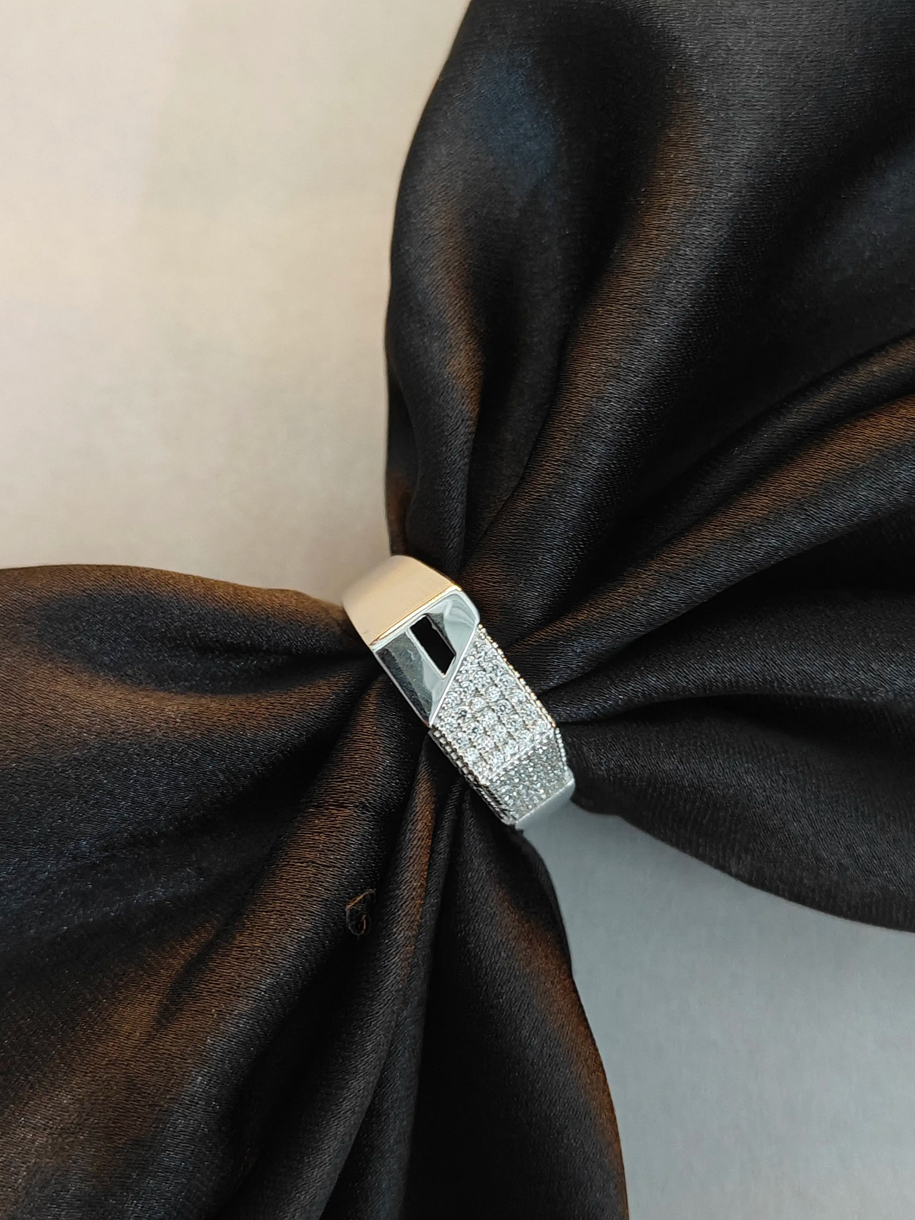 Silver ring with a bow on a black fabric background
