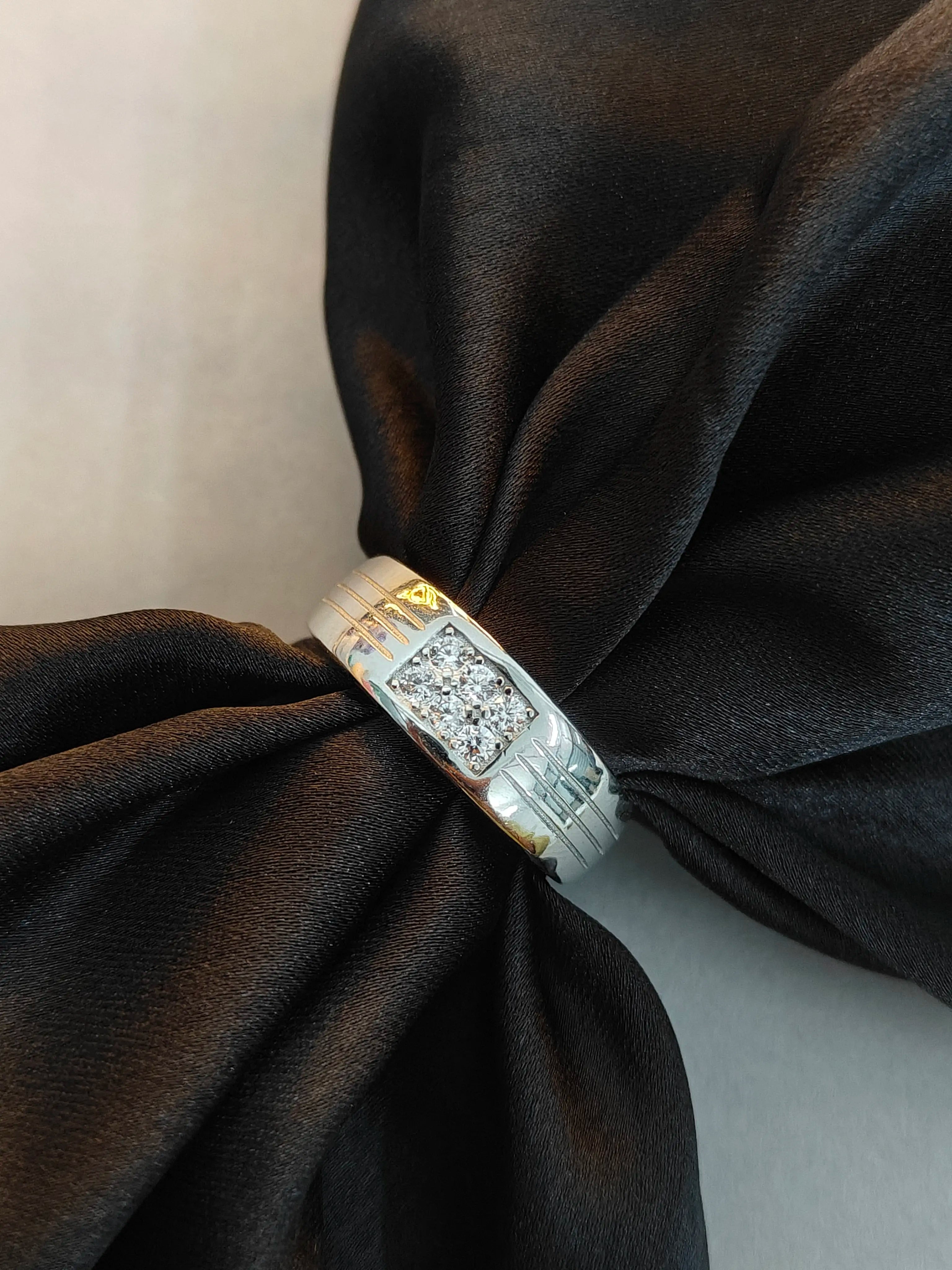 Silver ring with a diamond on black fabric