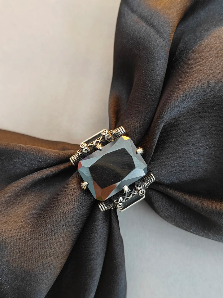 Ring with a large gemstone on a dark fabric background