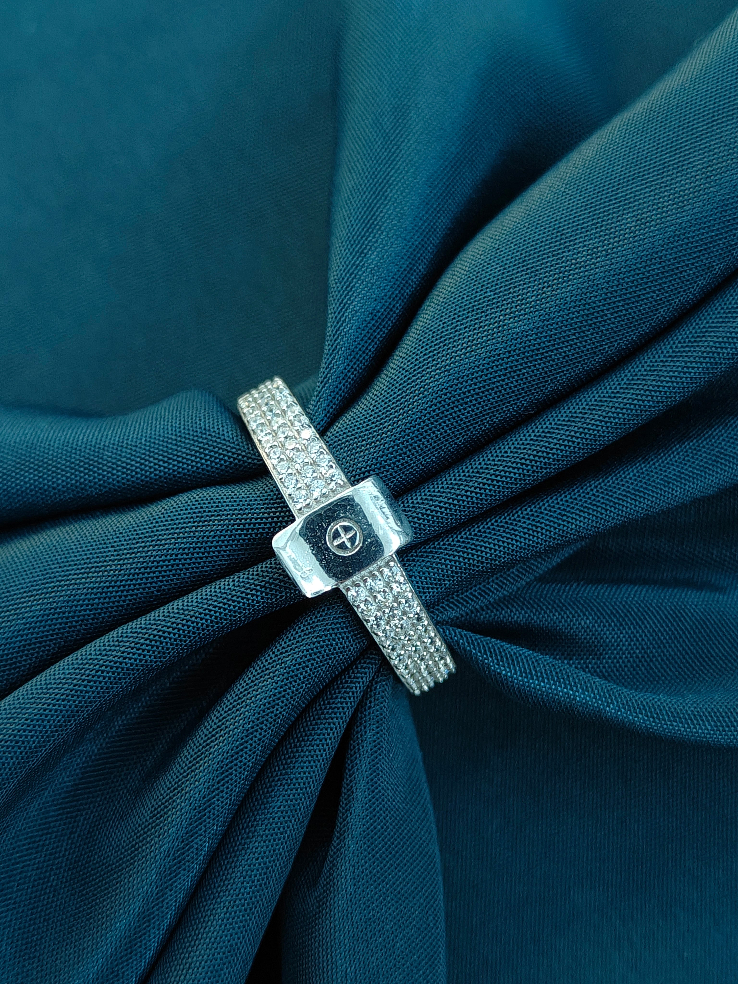 Silver bracelet with a clasp on a blue fabric background