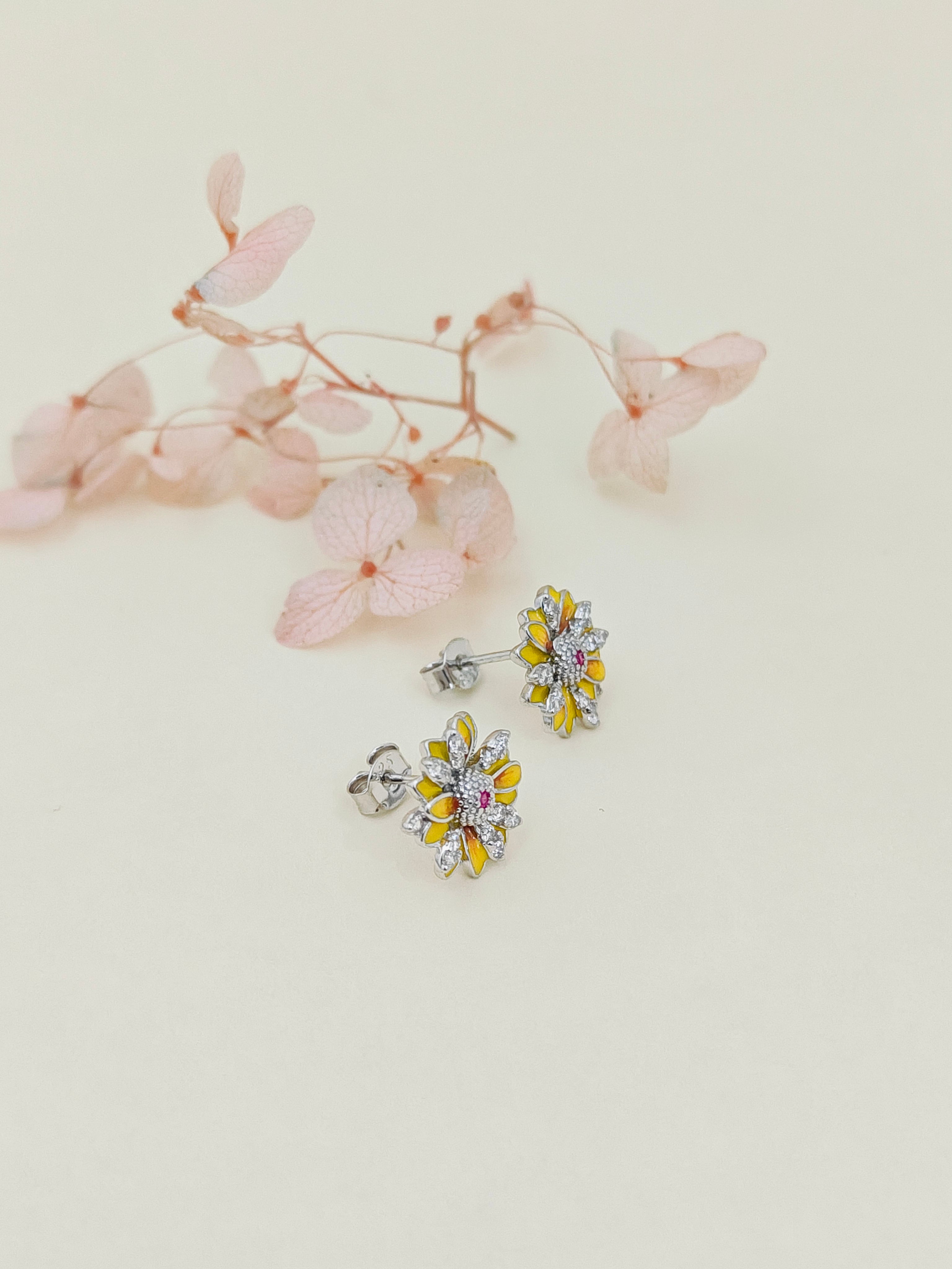 Floral earrings on a light background with pink flowers