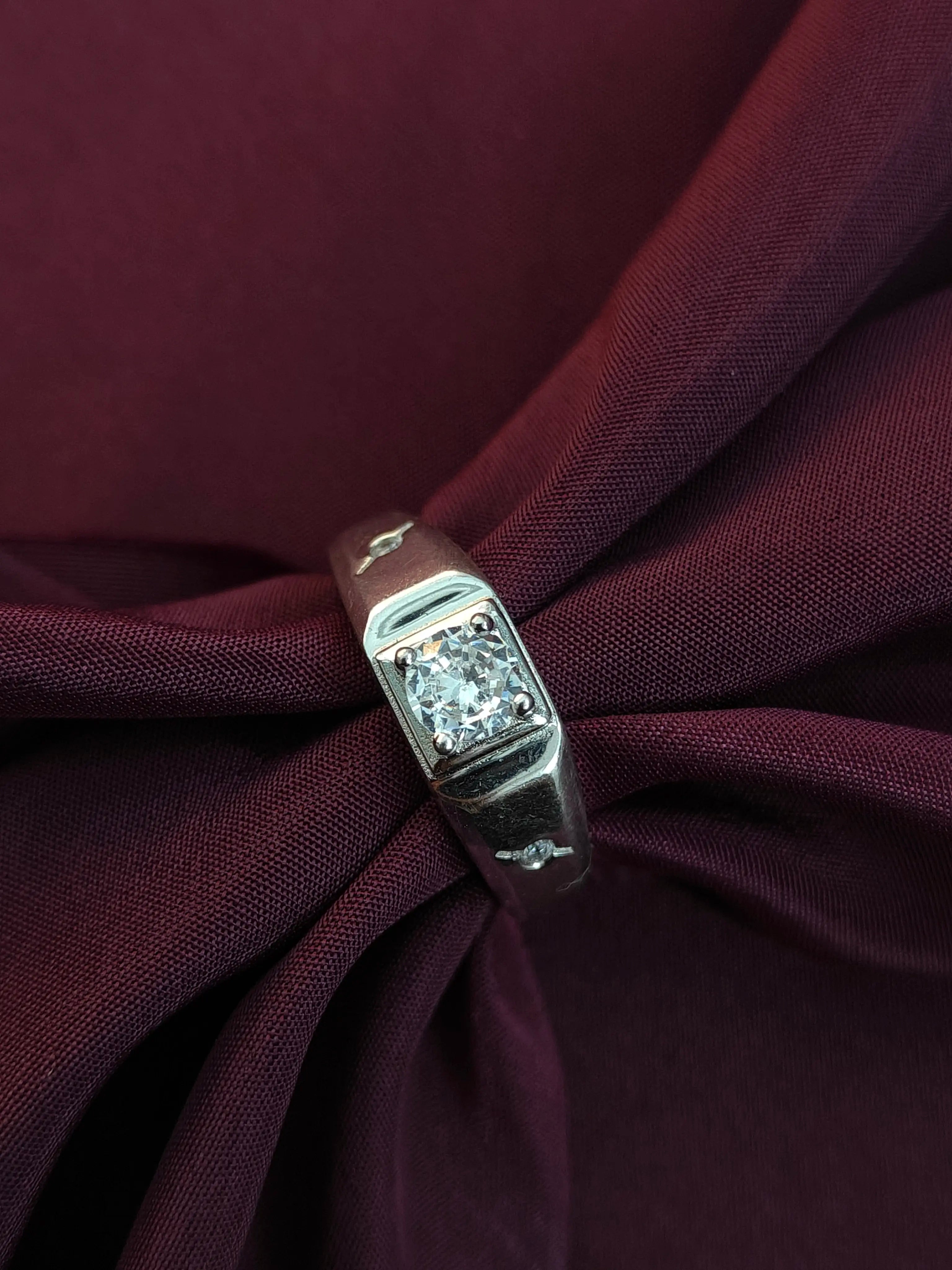 Diamond ring on a burgundy fabric background