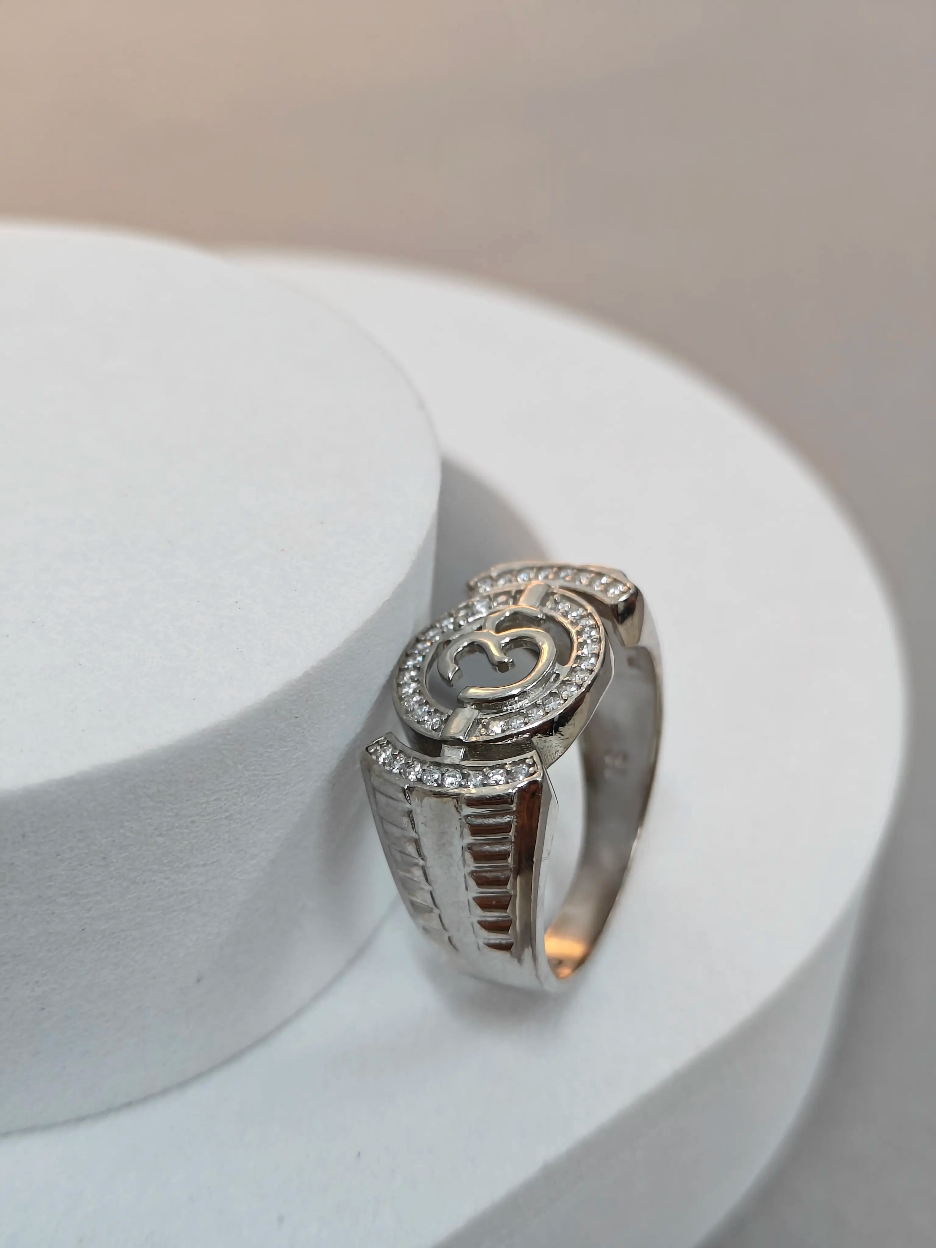 Silver ring with gemstones on a white stand