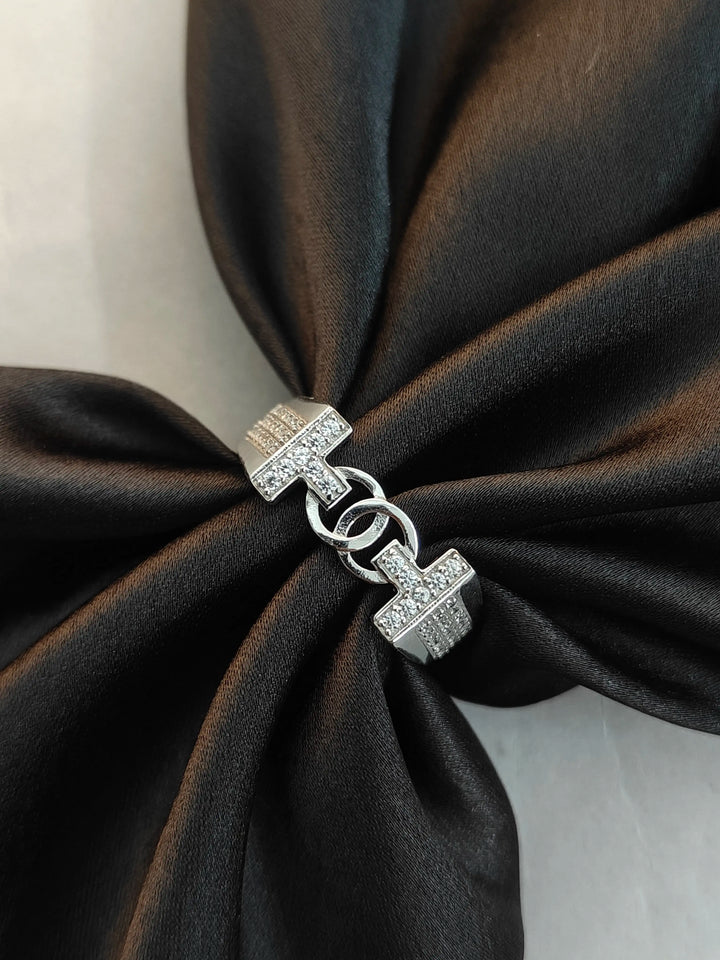 Silver bracelet with a clasp on a black fabric background