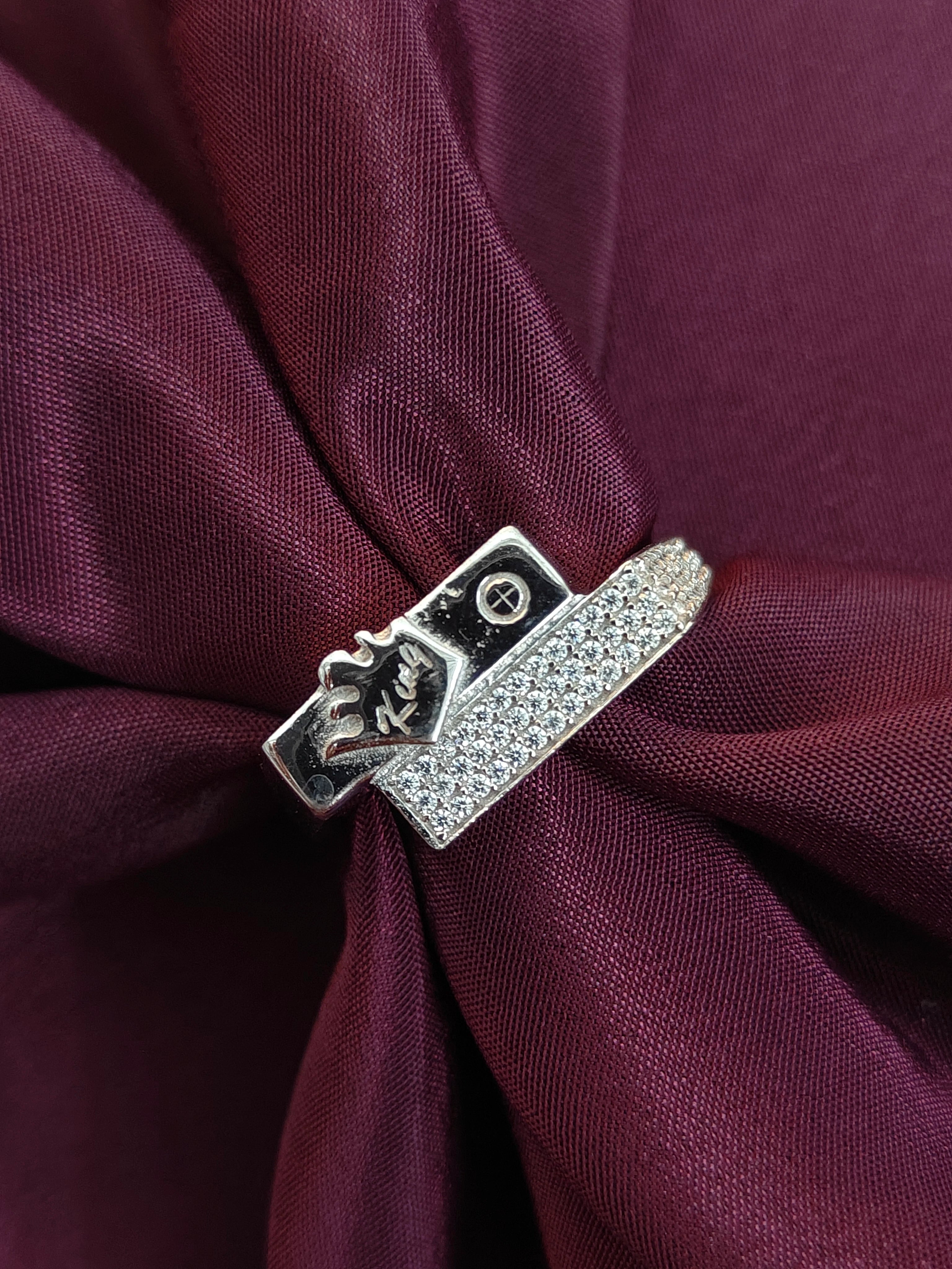 Silver belt buckle with clasp on a burgundy fabric background