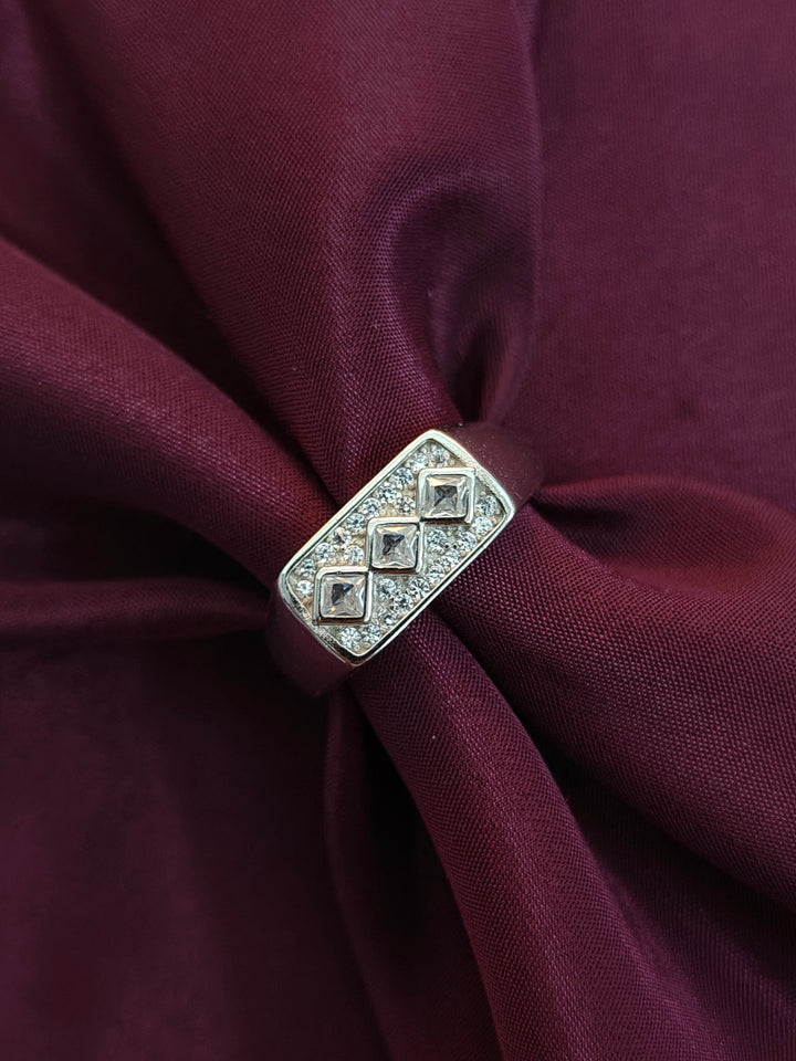 Silver brooch with diamond-like stones on a burgundy fabric background