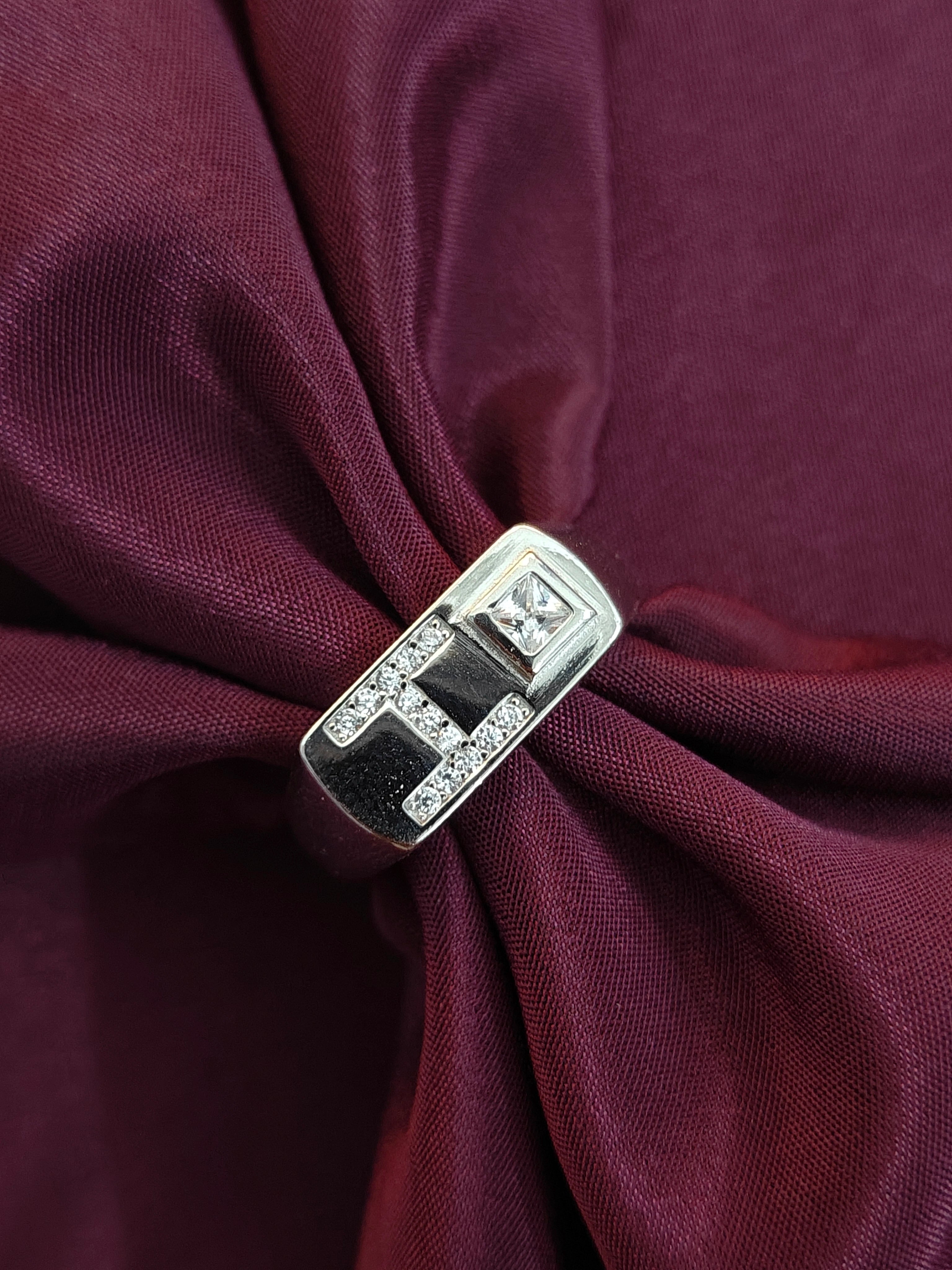 Silver brooch on a burgundy fabric background