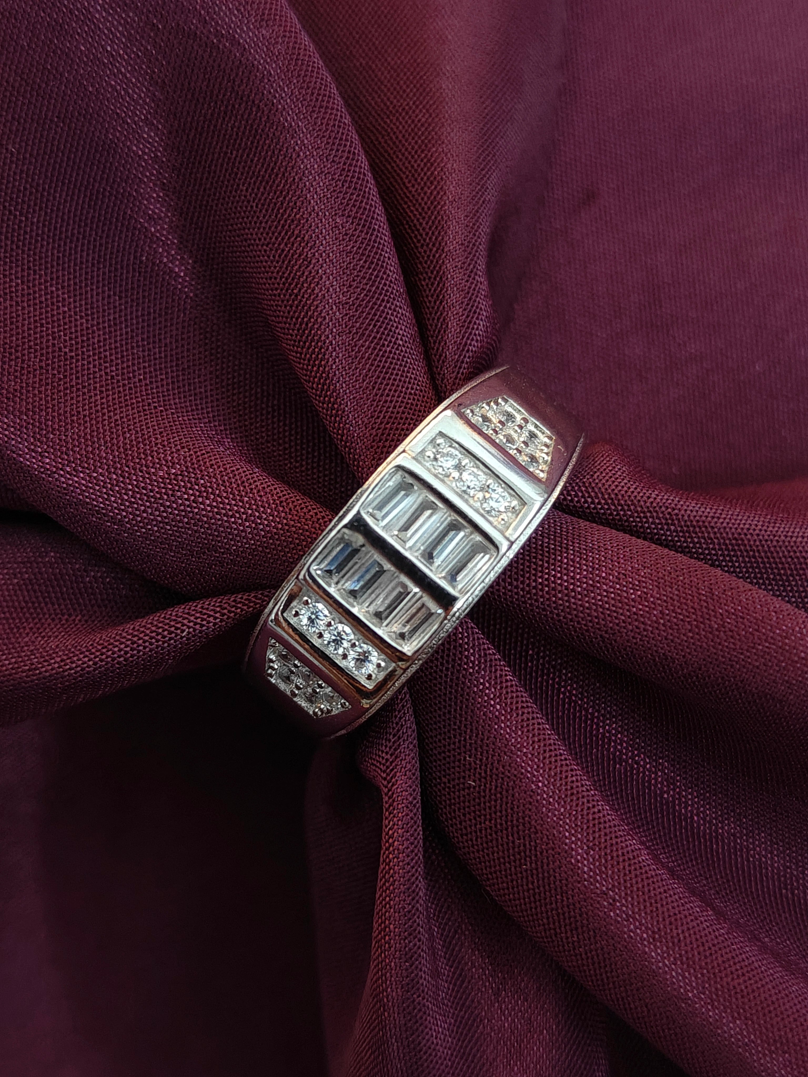 Silver ring with gemstones on a maroon fabric background