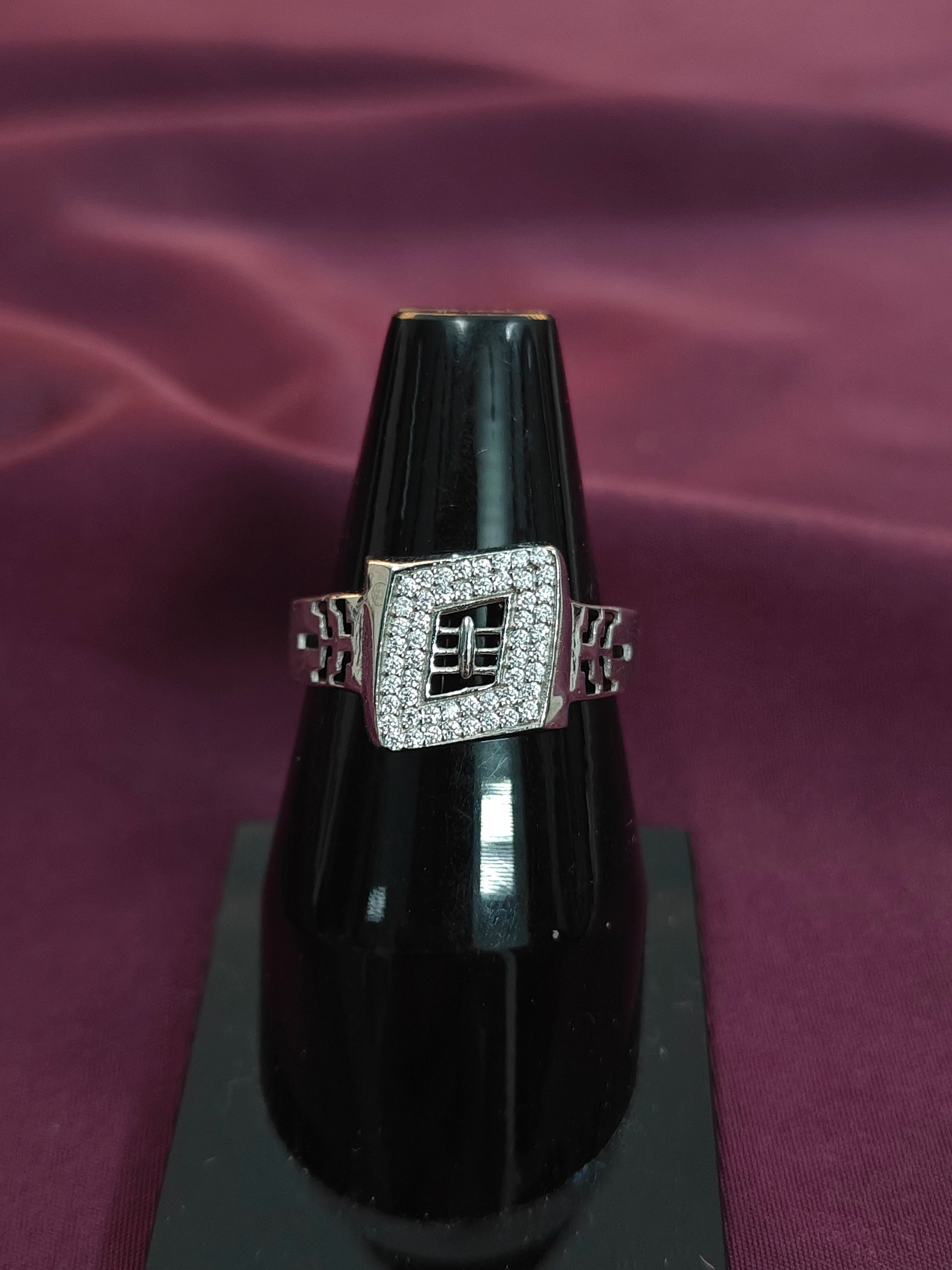 Diamond ring on a black stand with a purple fabric background