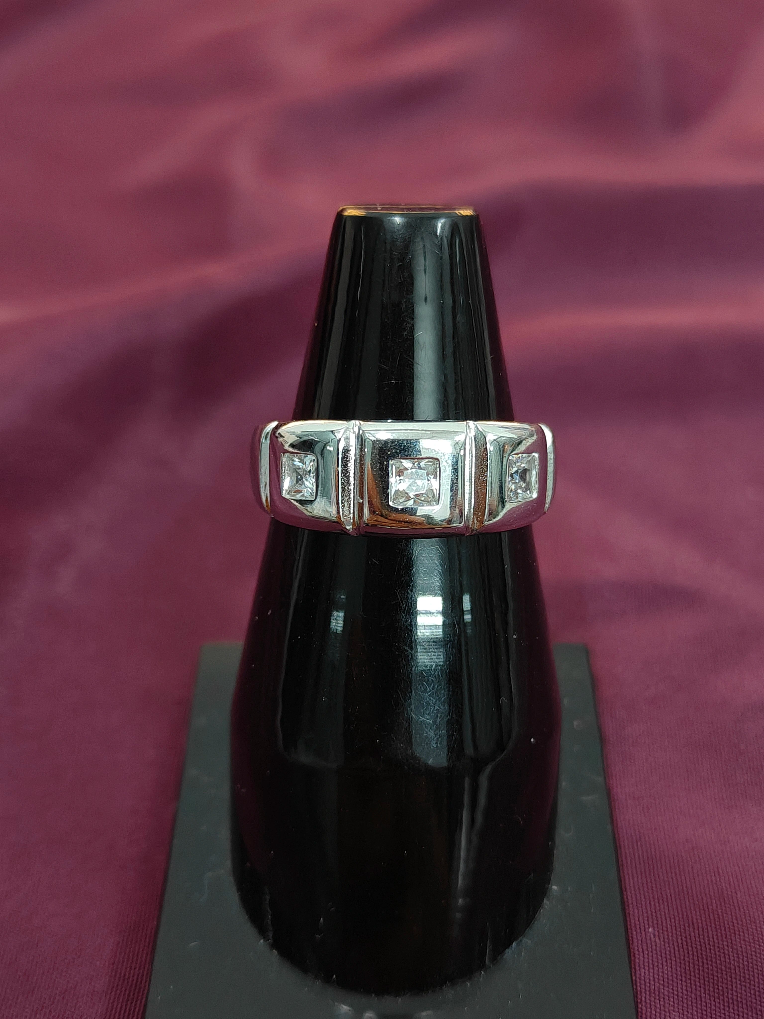 Diamond ring on a black stand with a purple fabric background