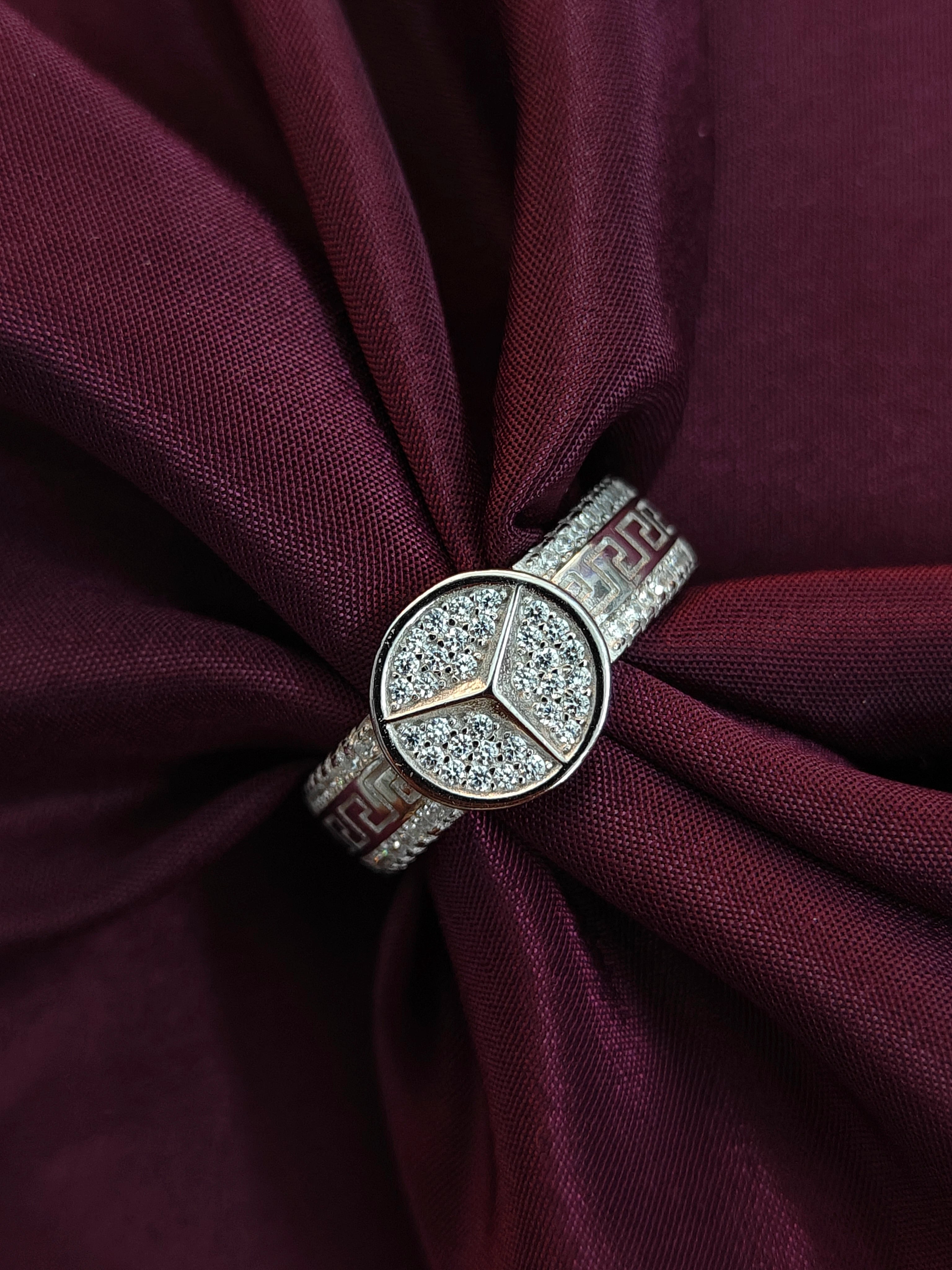 Diamond ring with a floral design on a burgundy fabric background