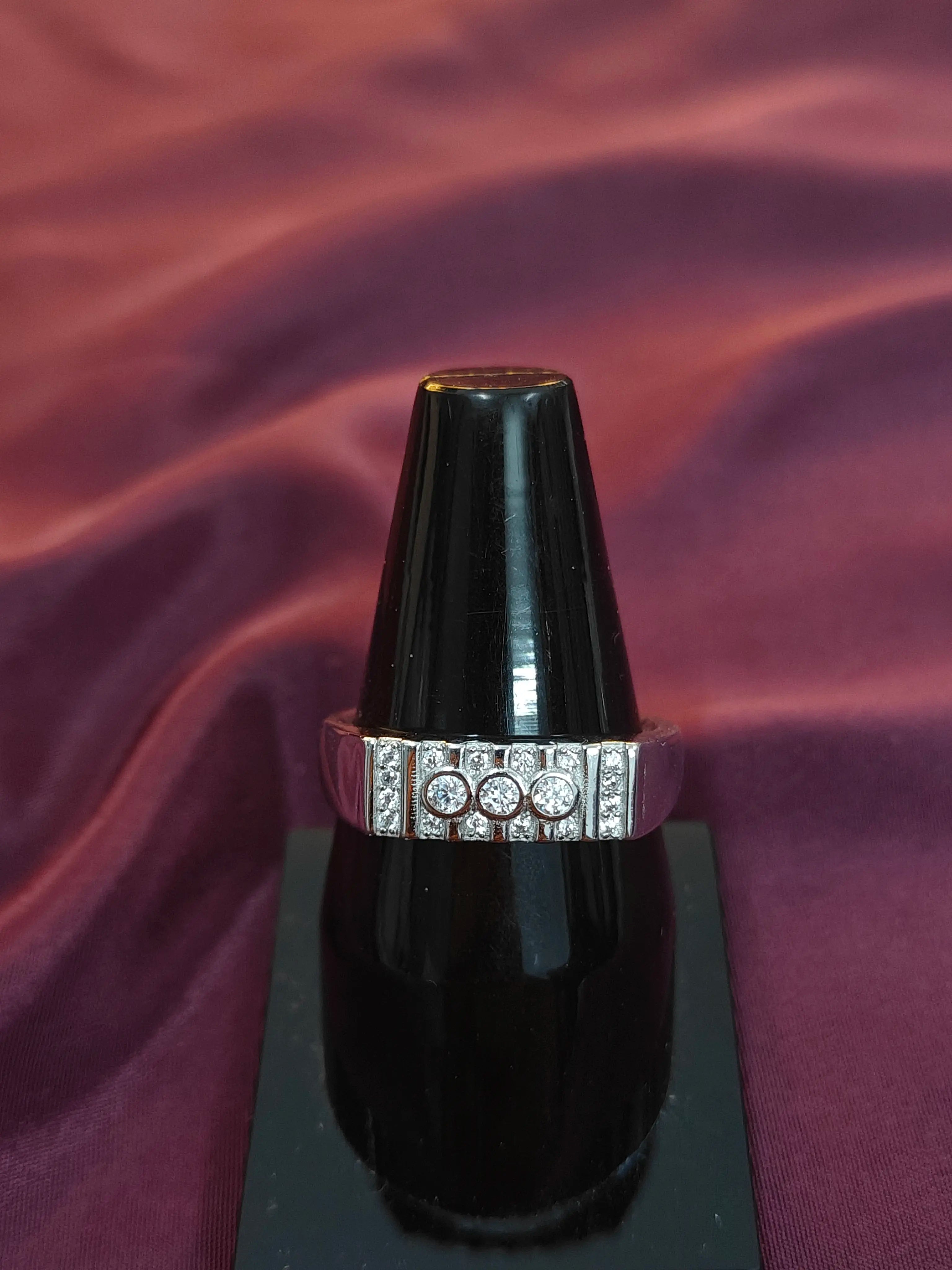 Black lipstick with a silver and diamond accent on a purple fabric background