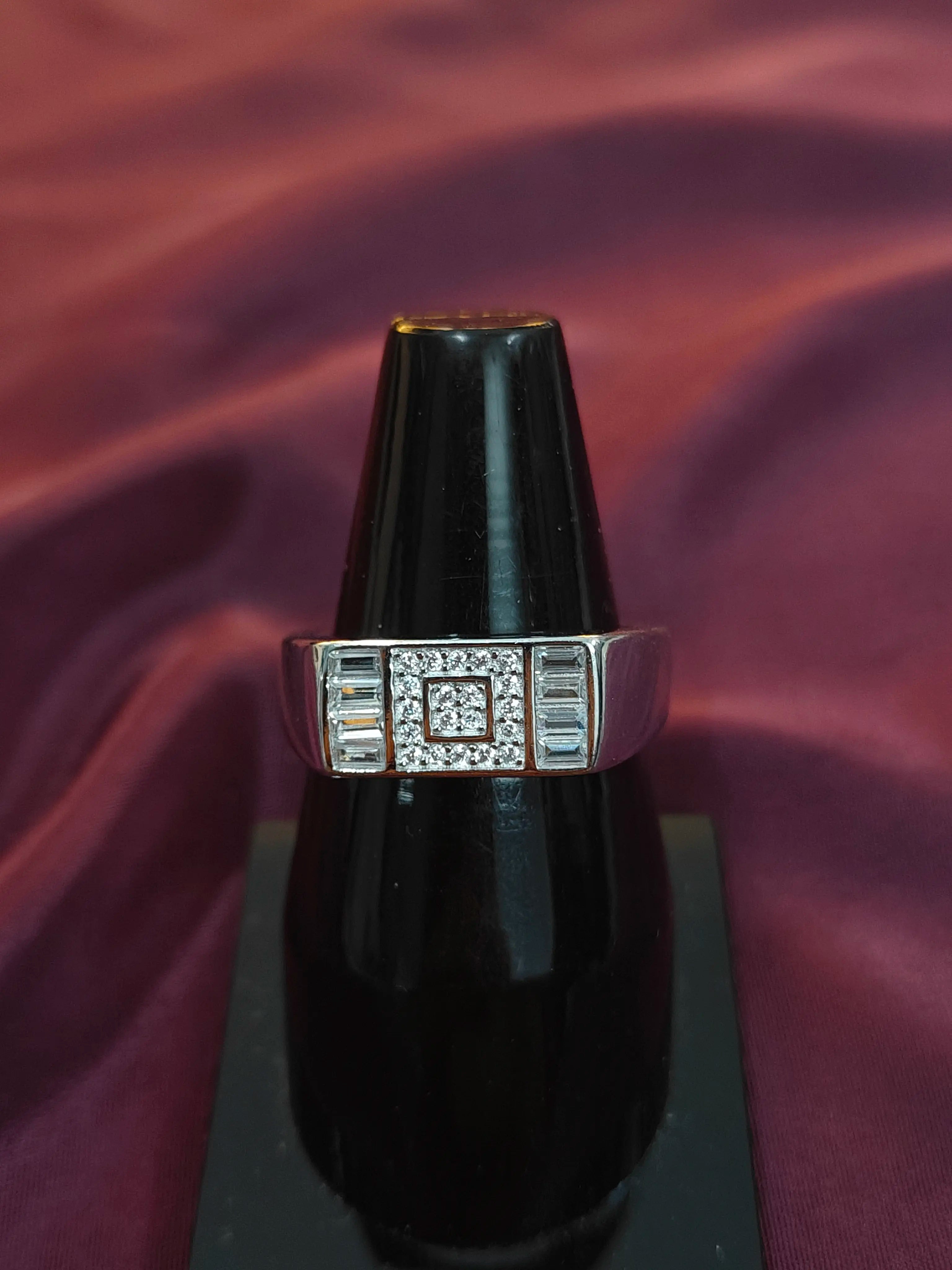 Diamant ring on a black stand with a purple fabric background