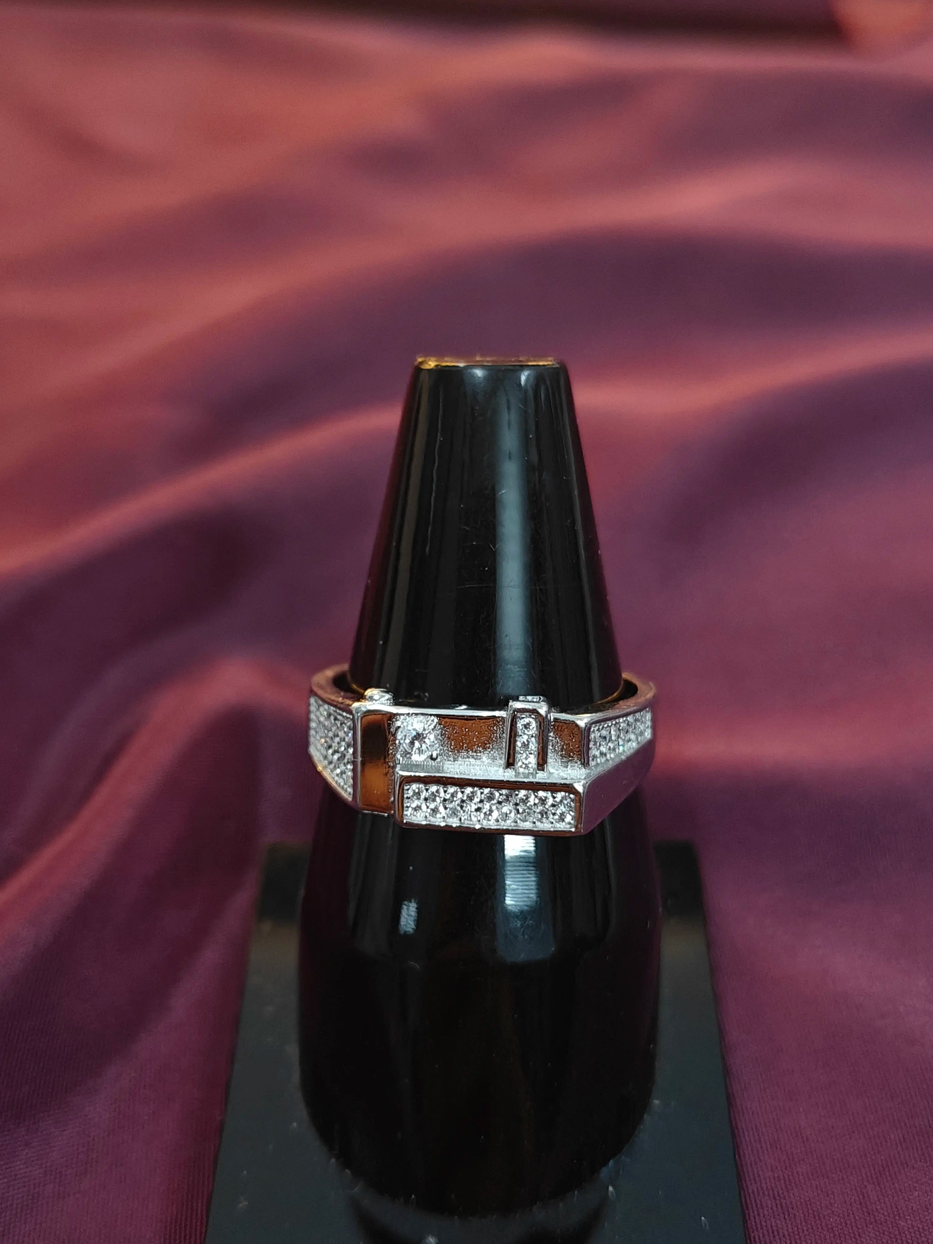 Ring on a black stand with a purple fabric background
