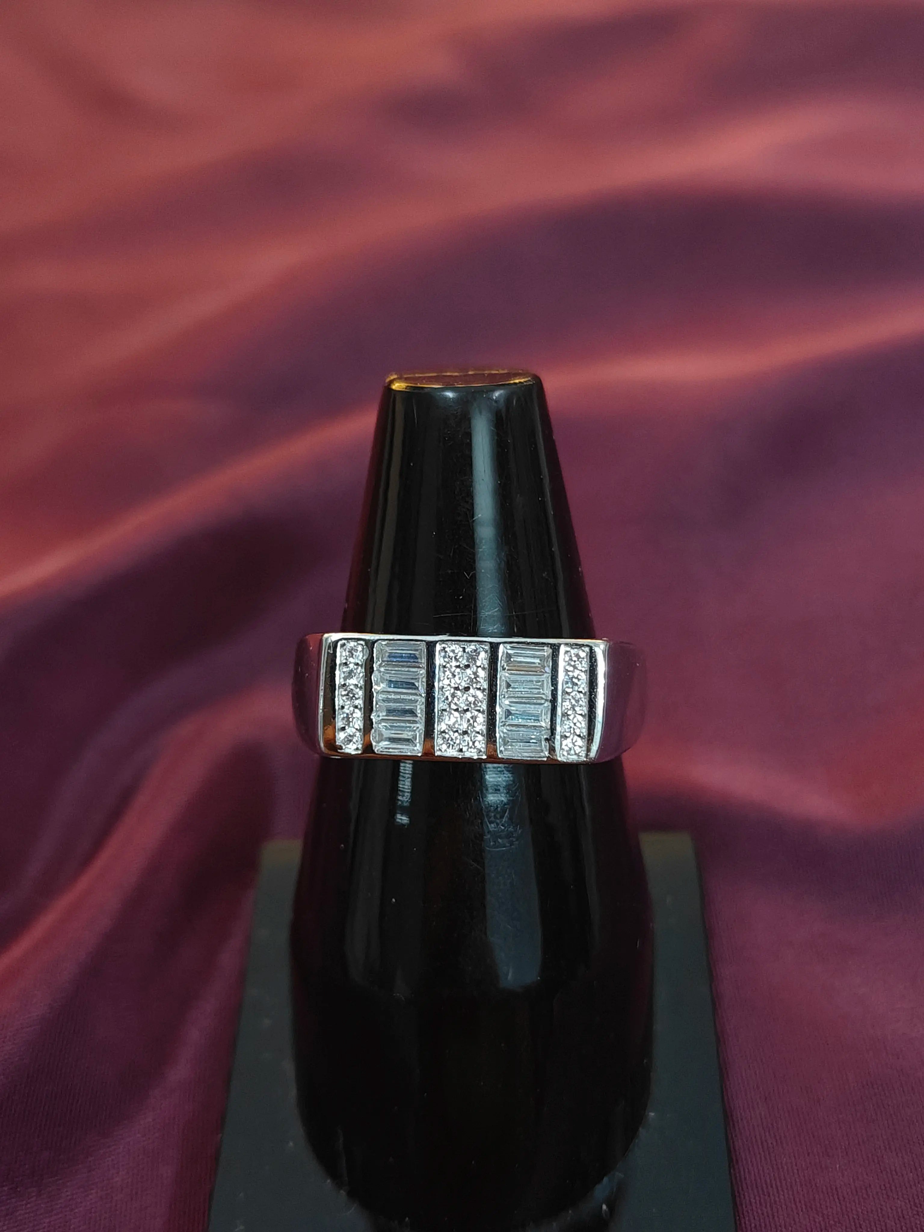 Diamond ring on a black stand against a purple fabric background
