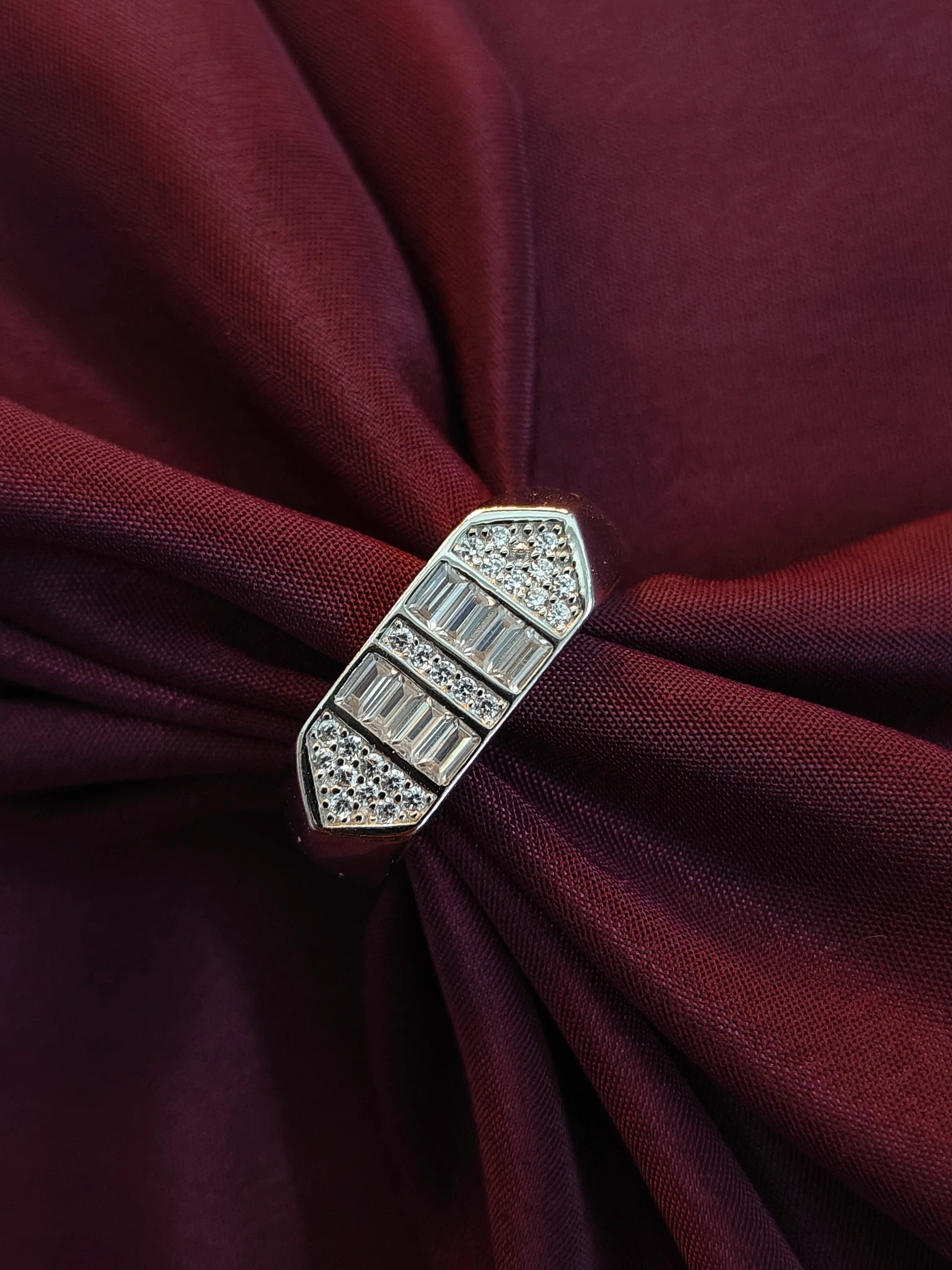 Silver brooch with gemstones on a burgundy fabric background