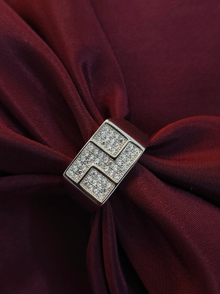 Silver brooch with gemstones on a burgundy fabric background