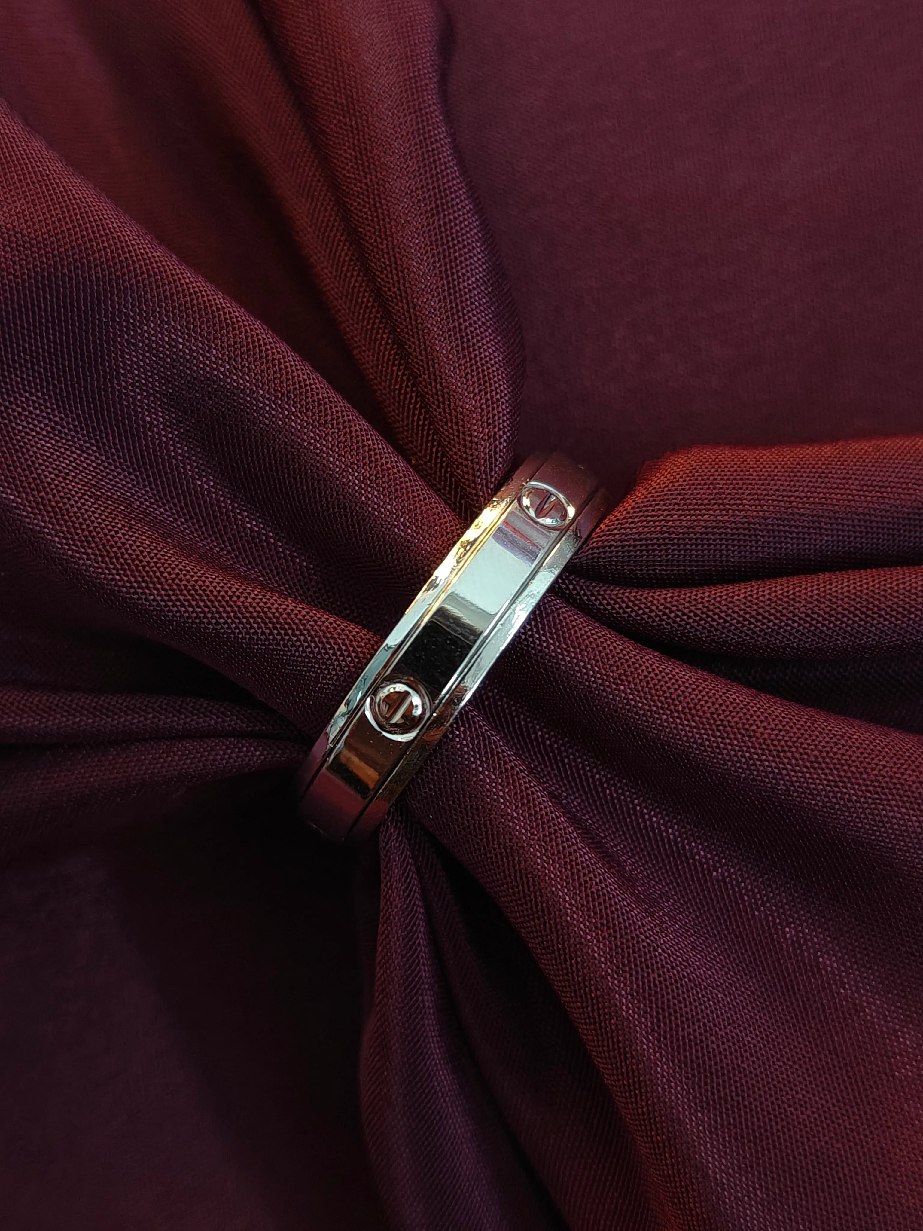Silver ring on a knotted burgundy fabric