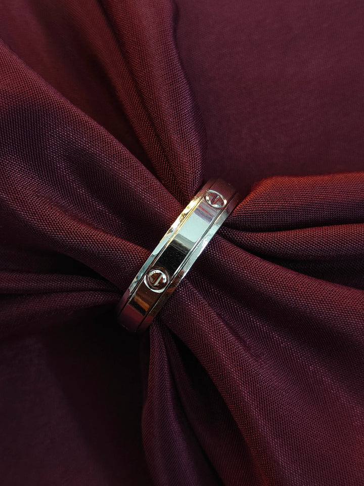 Silver ring on a knotted burgundy fabric