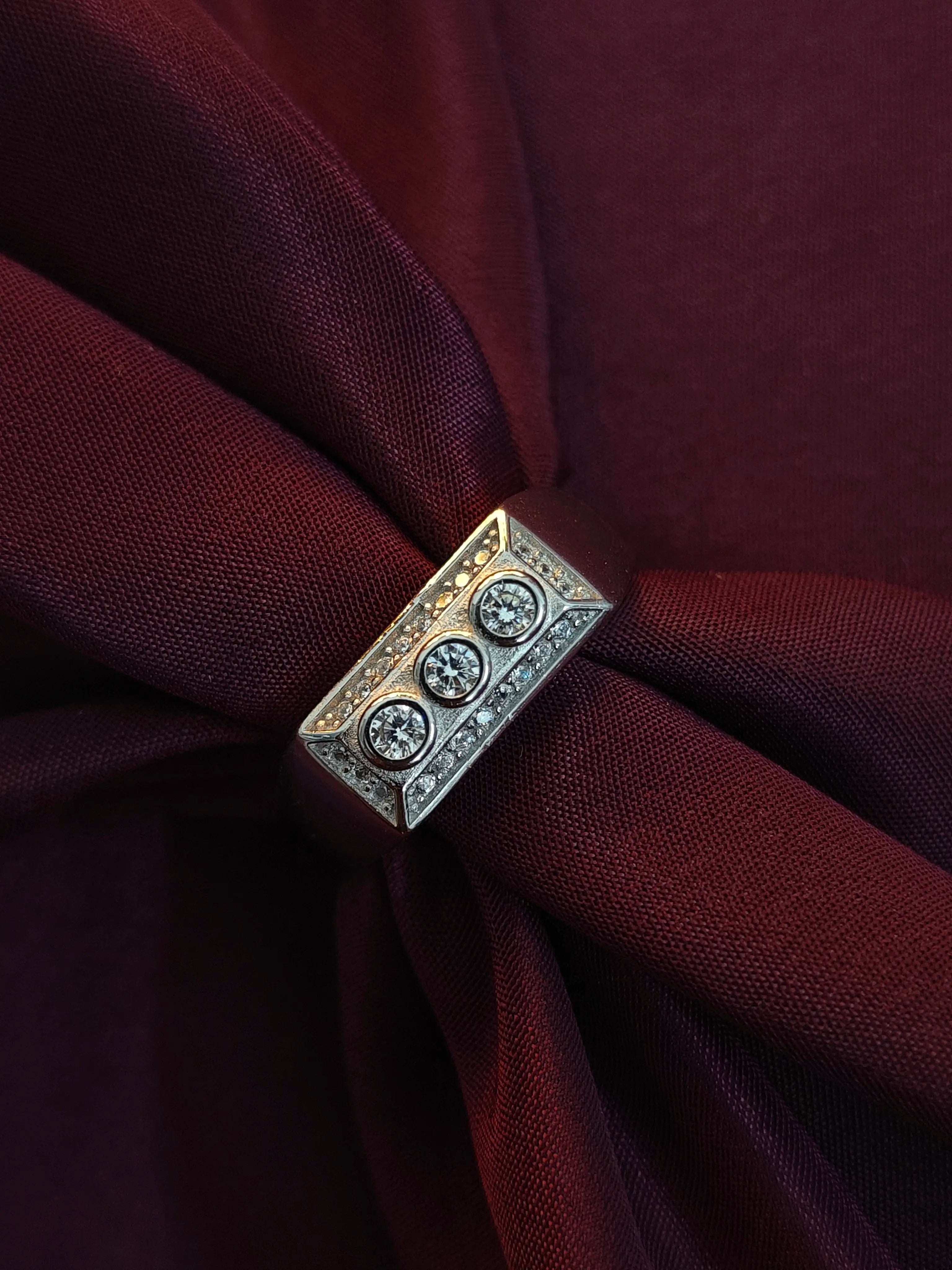 Decorative brooch with gemstones on a burgundy fabric background