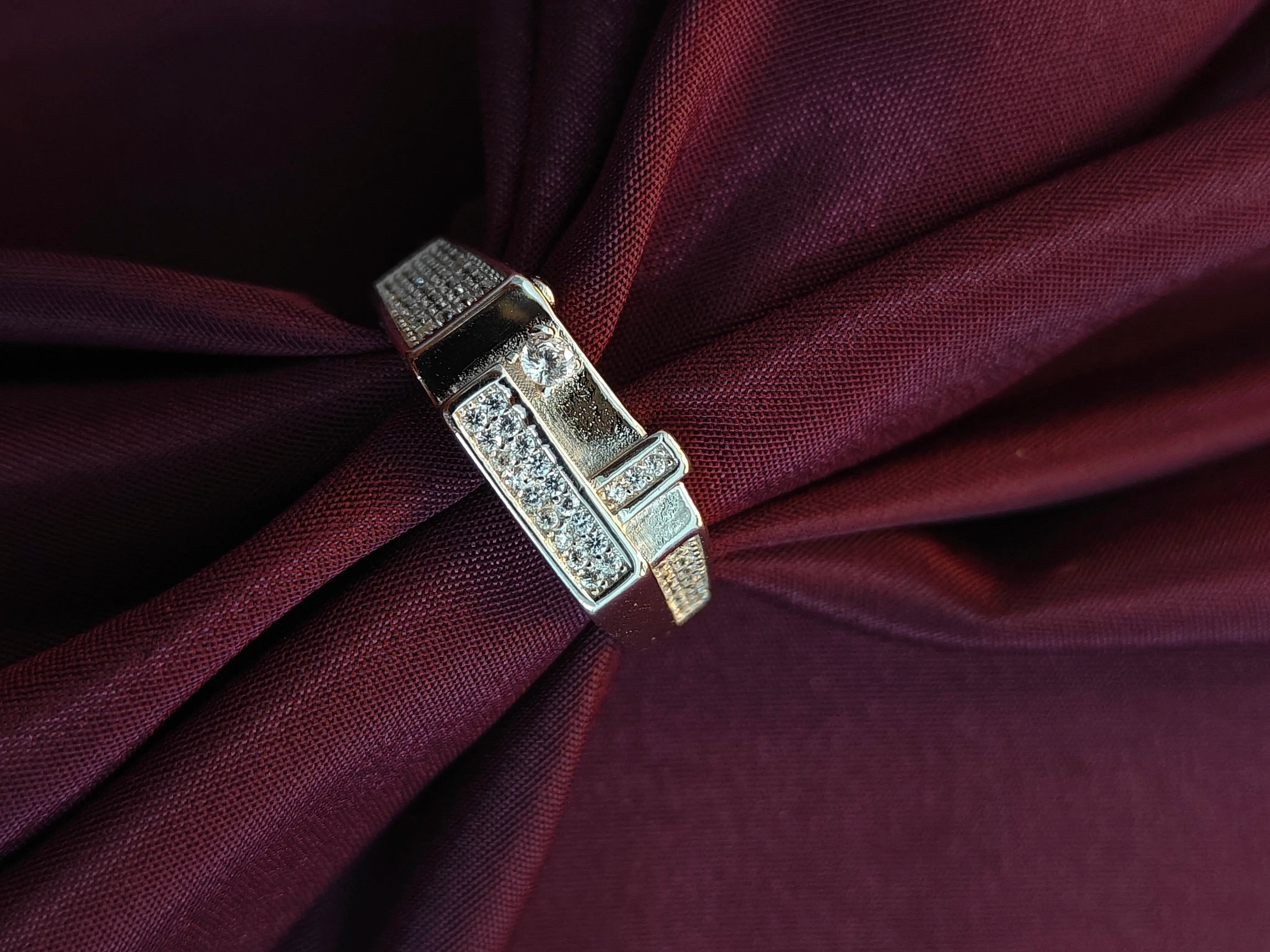 Decorative brooch with gemstones on a burgundy fabric background