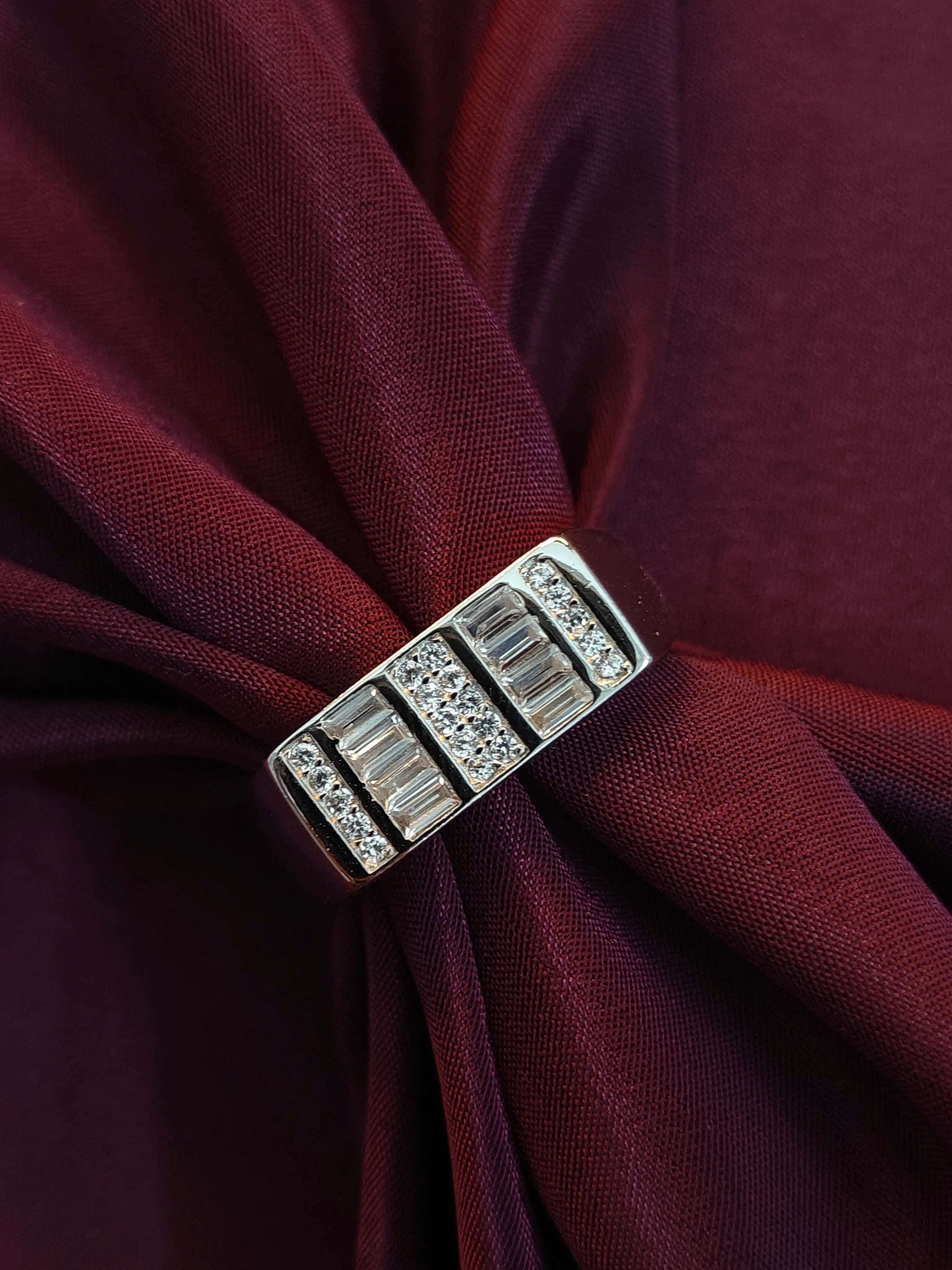 Silver brooch with gemstones on a burgundy fabric background