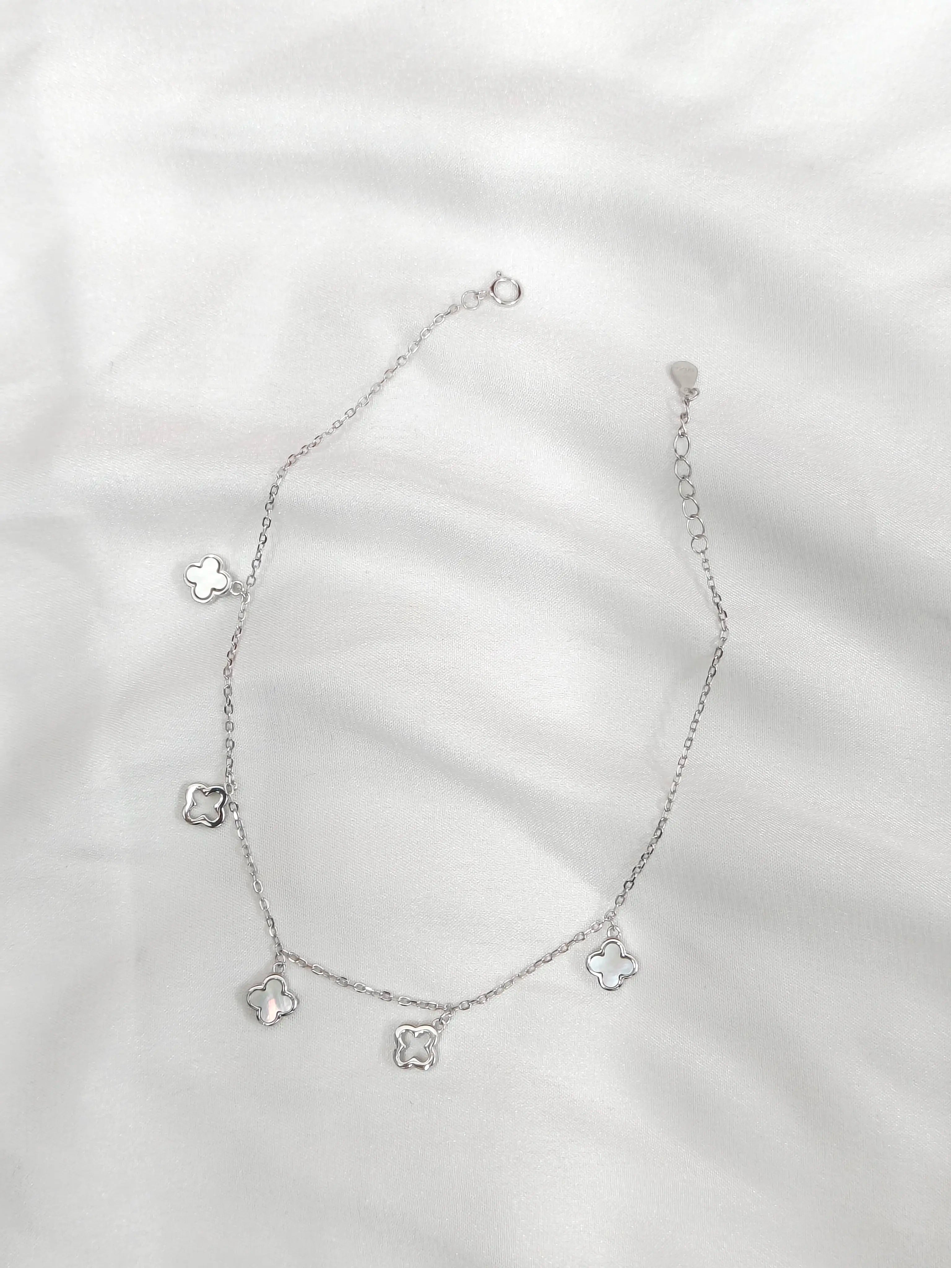 Silver necklace with heart-shaped charms on a white background