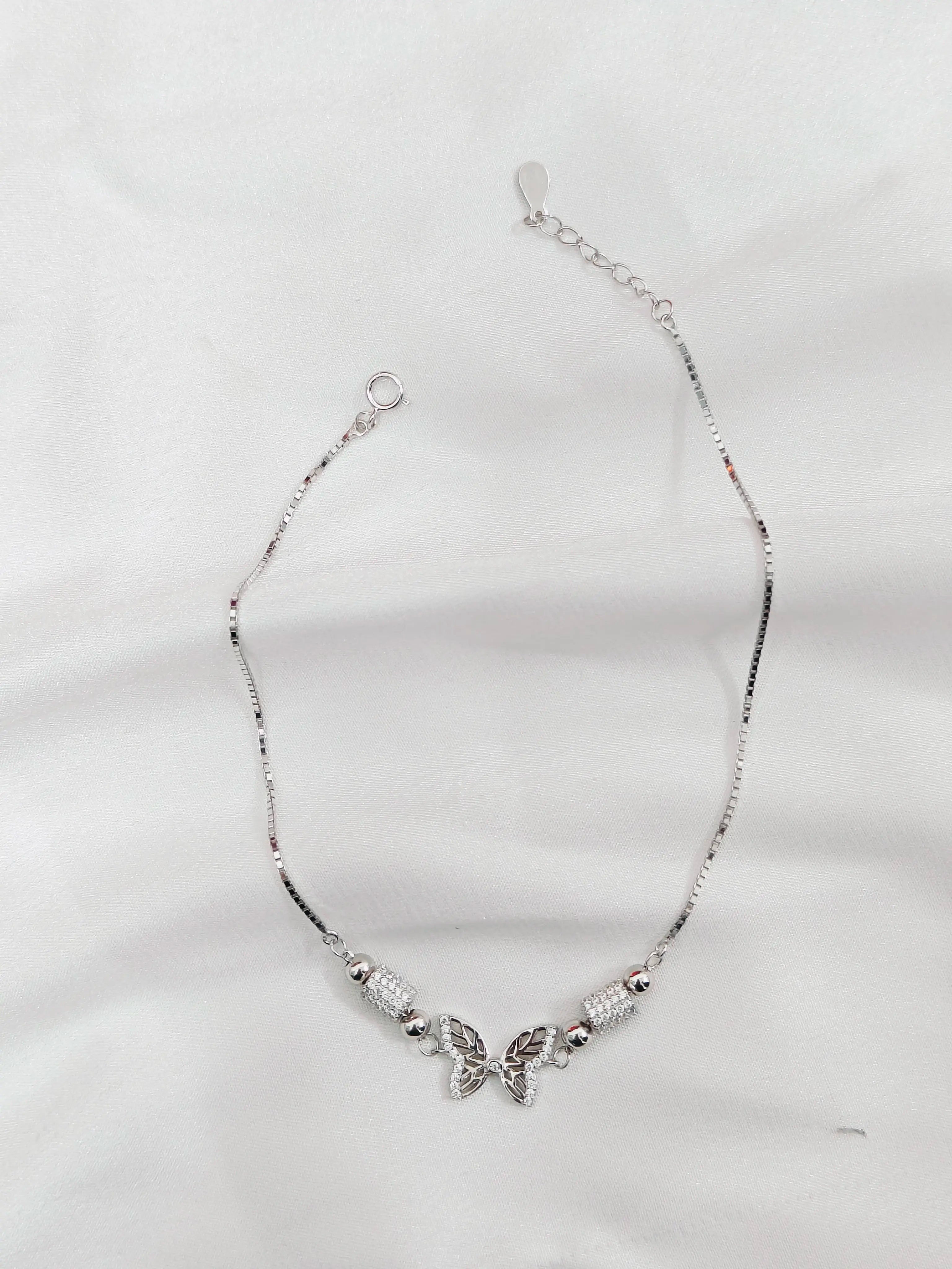 Silver necklace with butterfly charms on a white background