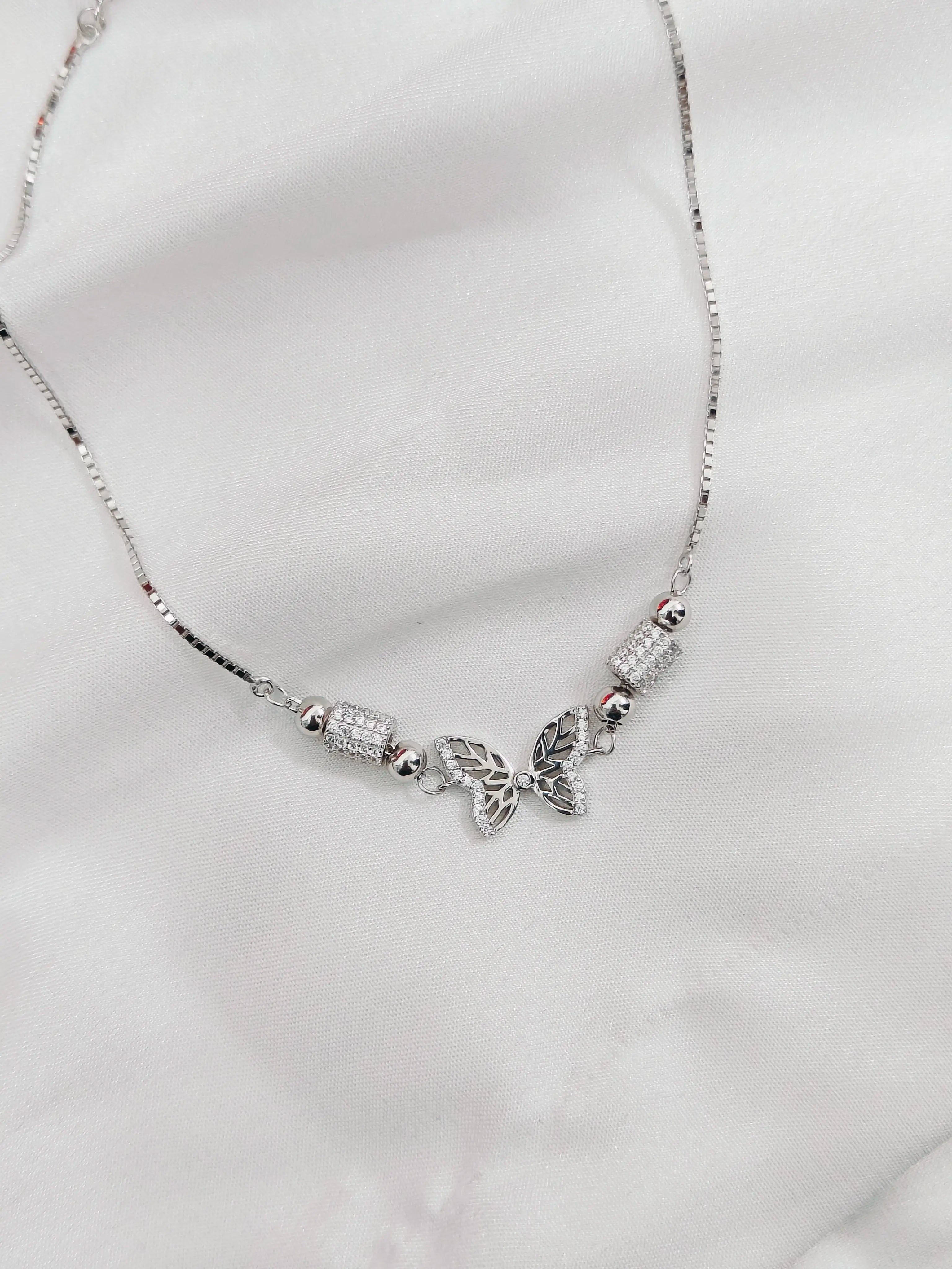 Silver necklace with a trinity knot pendant on a white background