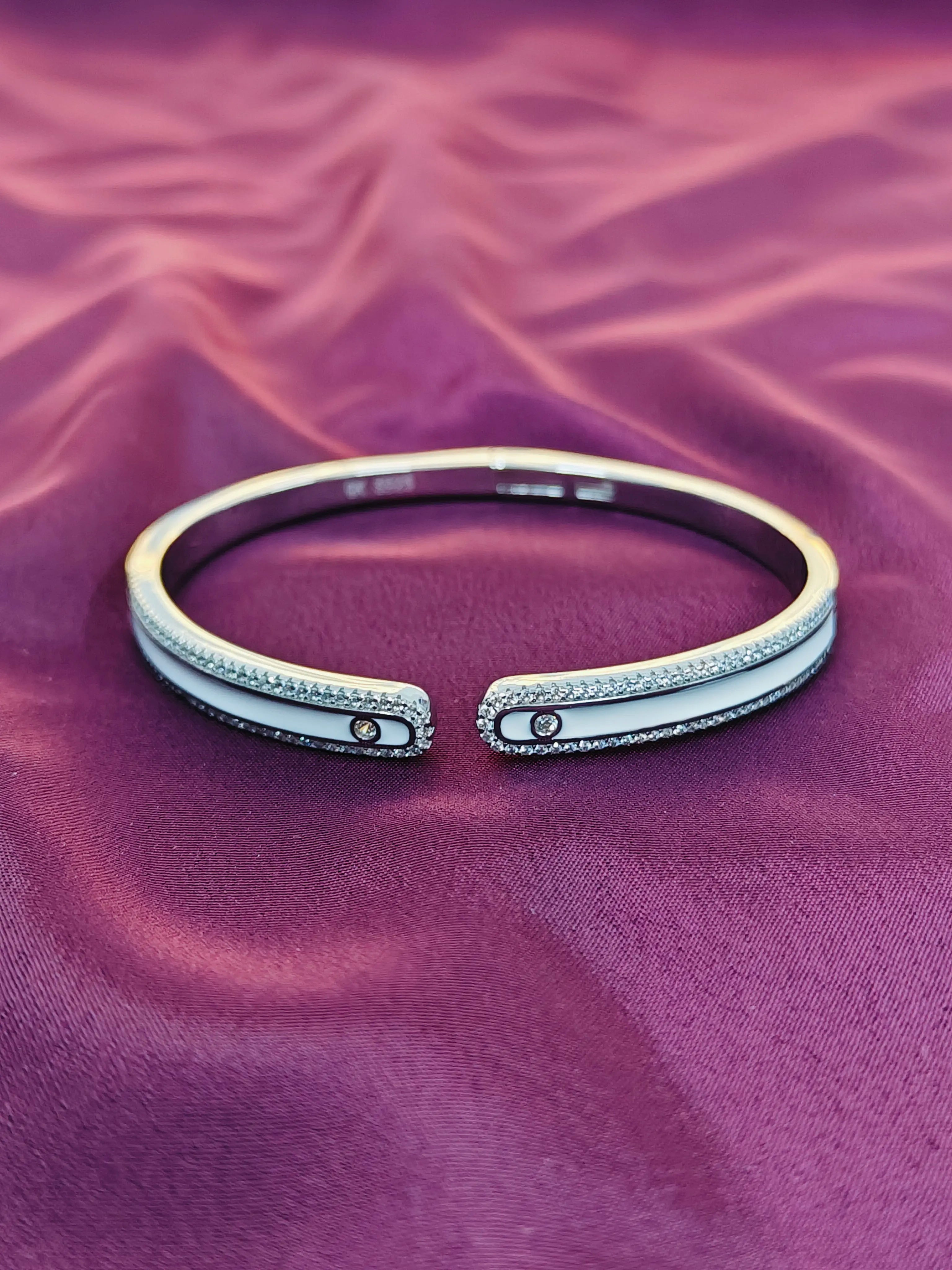 Silver bracelet with gemstones on a purple fabric background