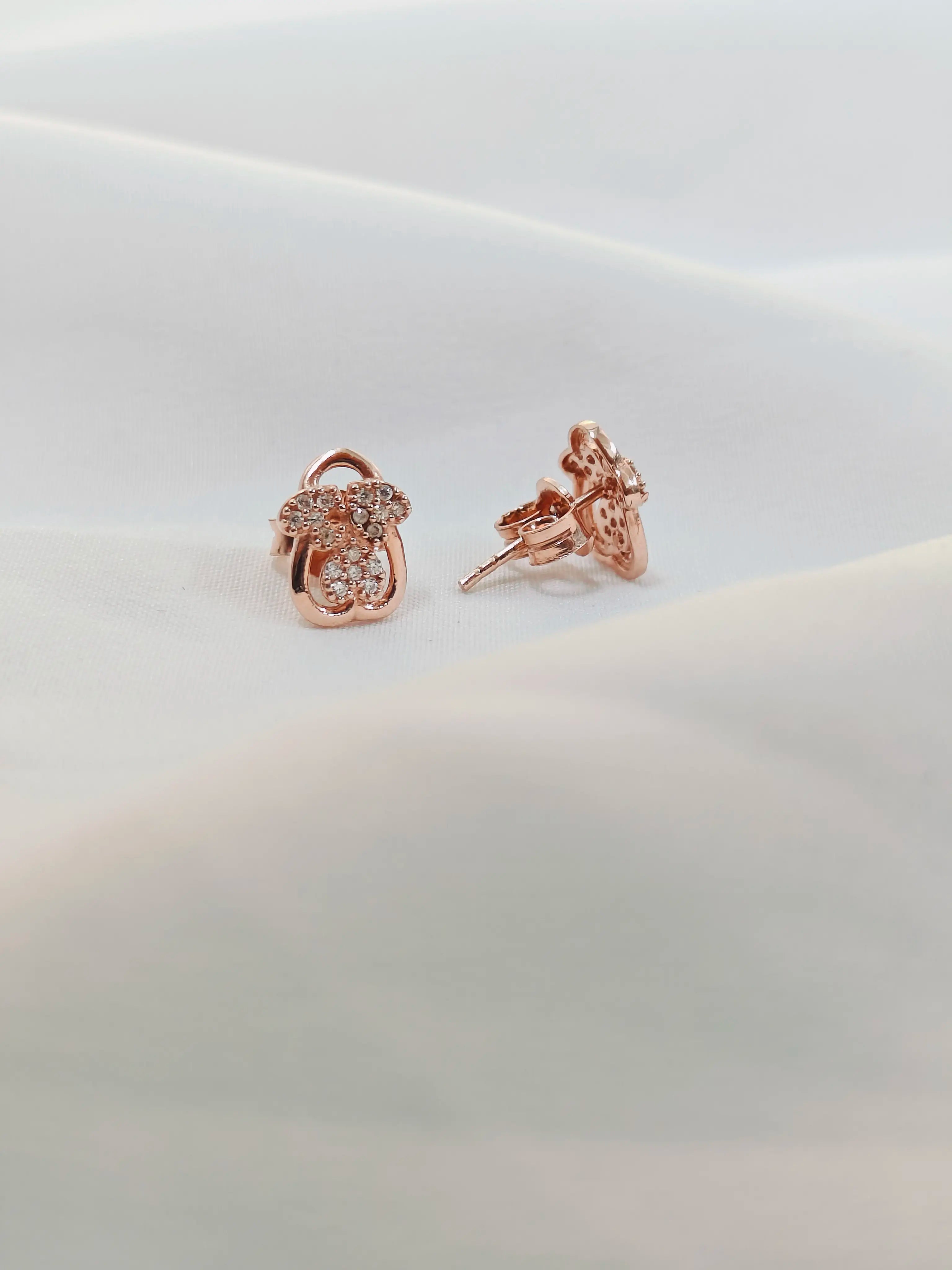 Rose gold earrings on a light gray background