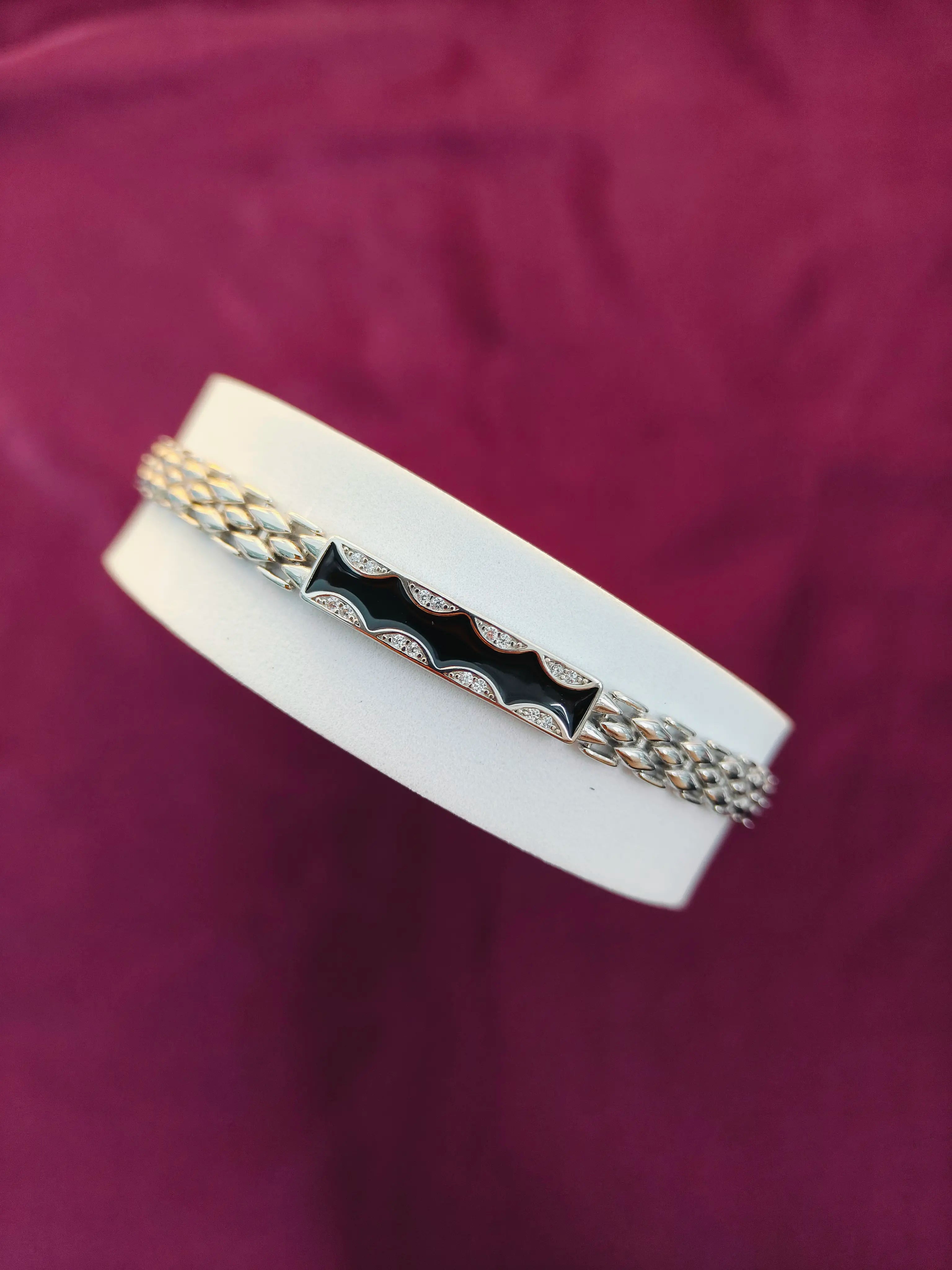 Bracelet with white band and silver and gold accents on a purple background