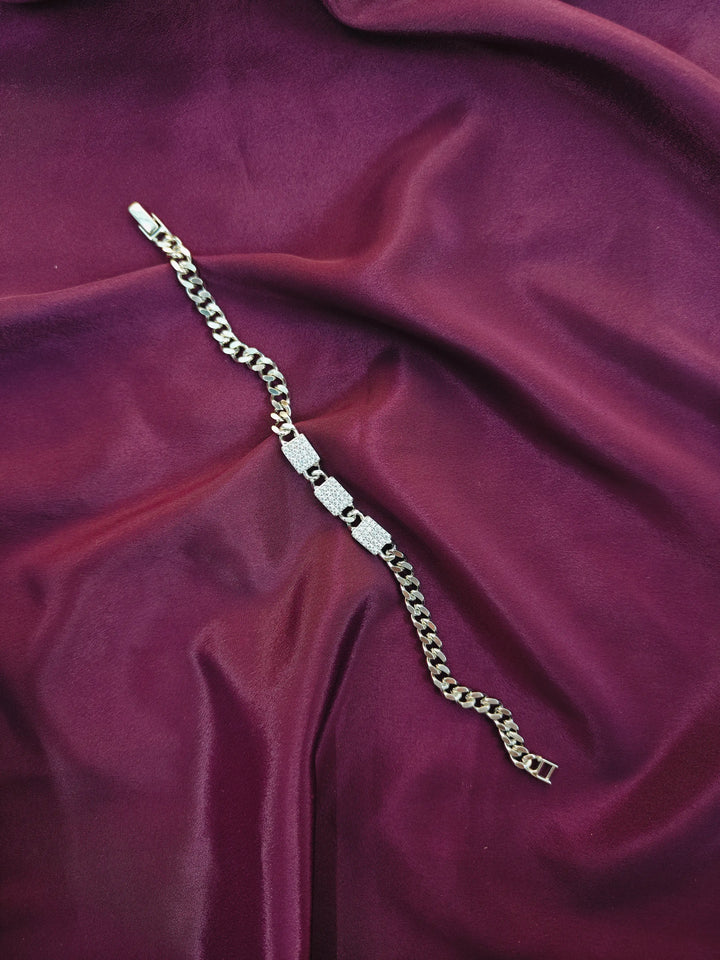 Silver chain bracelet on a purple fabric background