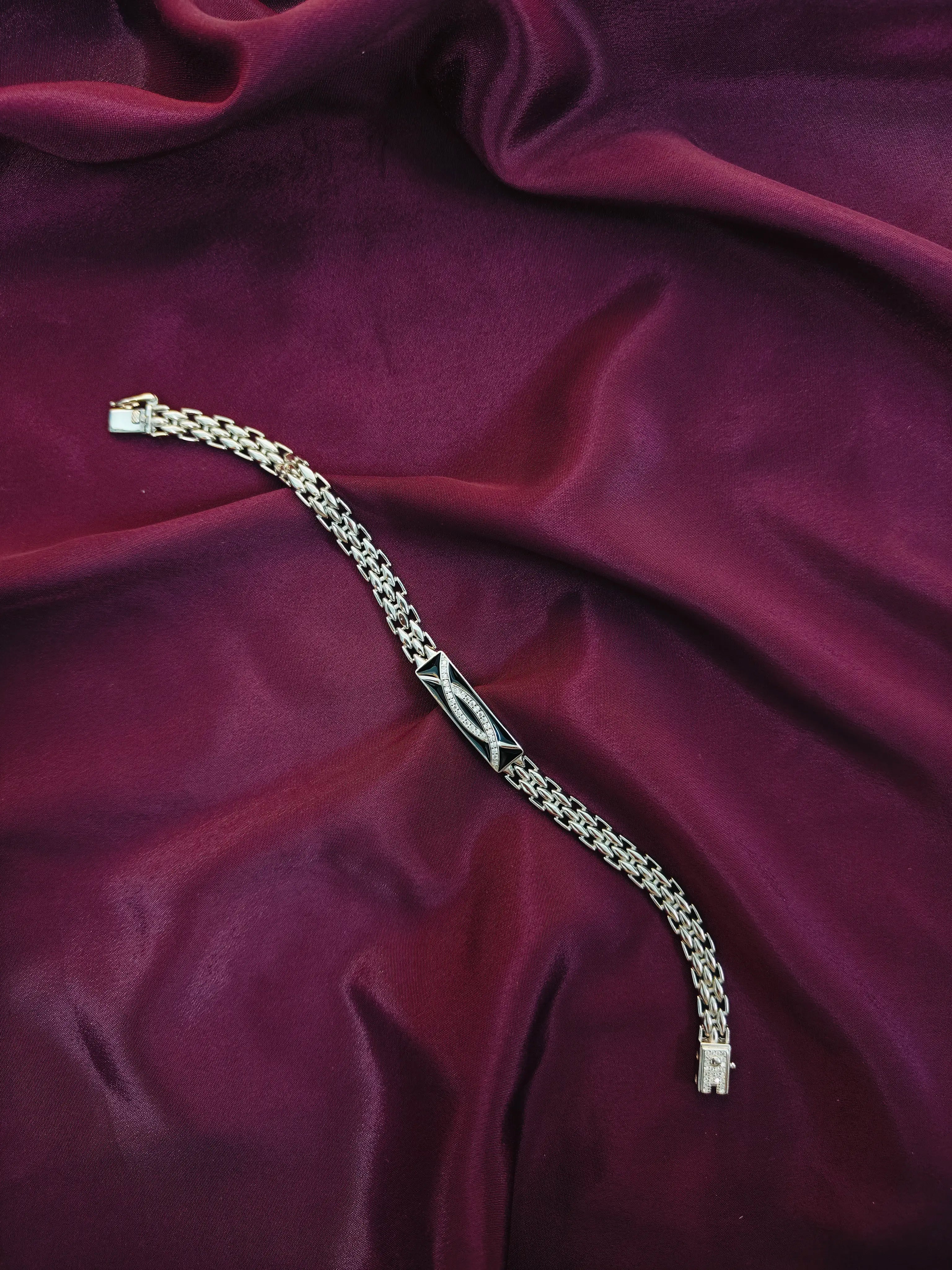 Silver bracelet with a fish symbol on a purple fabric background