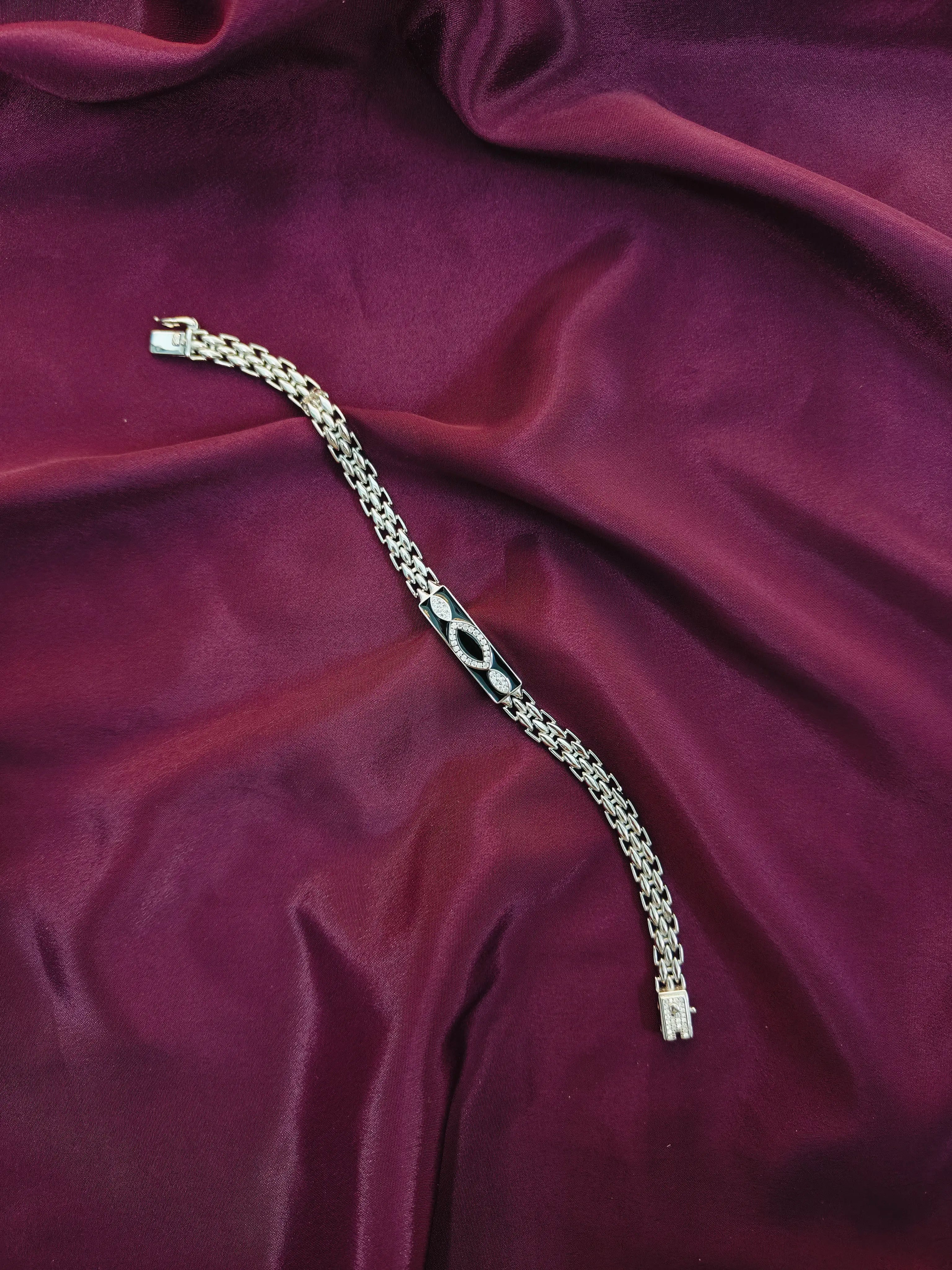 Silver bracelet on a maroon fabric background