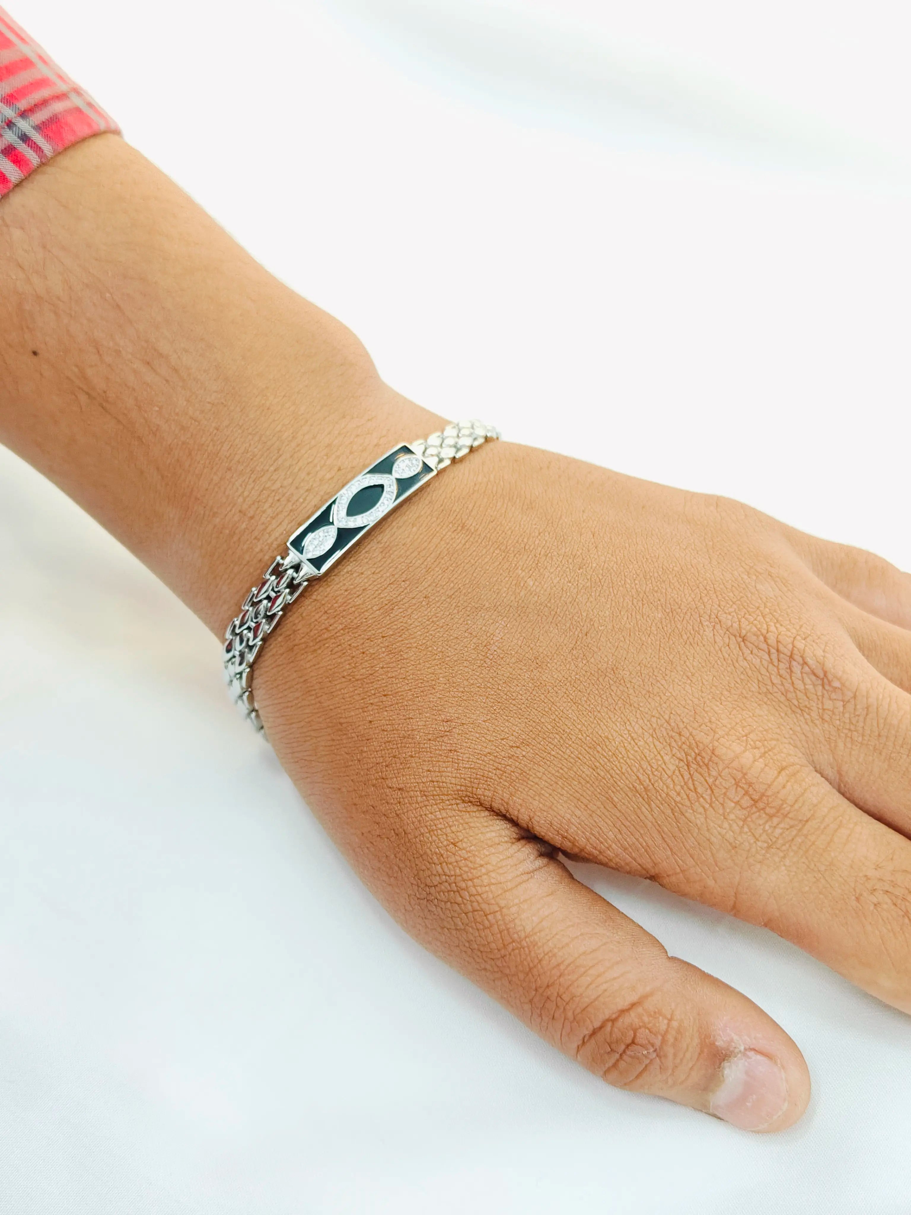 Hand wearing a silver bracelet on a white background
