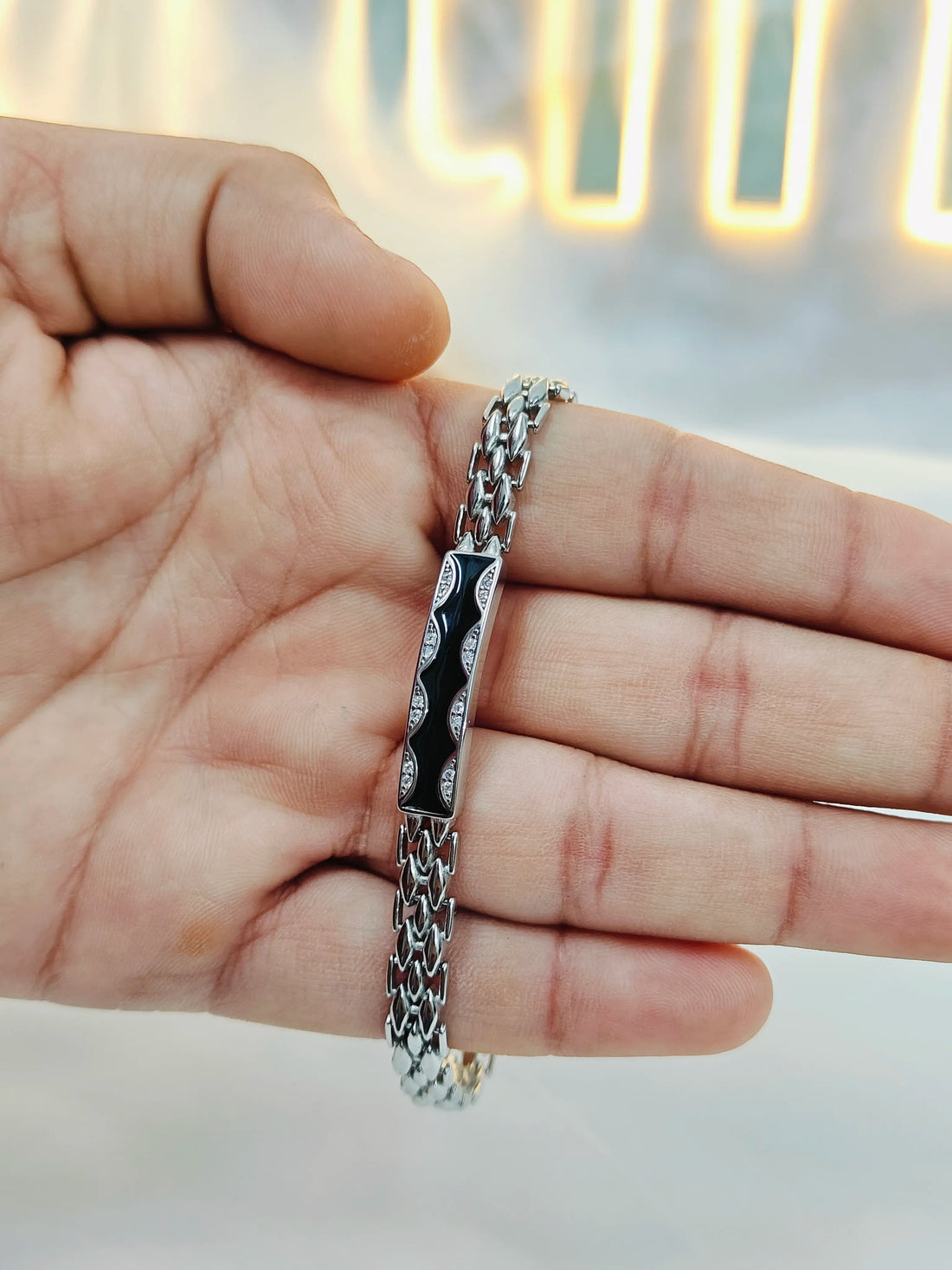 Silver chain bracelet on a hand with a blurred background