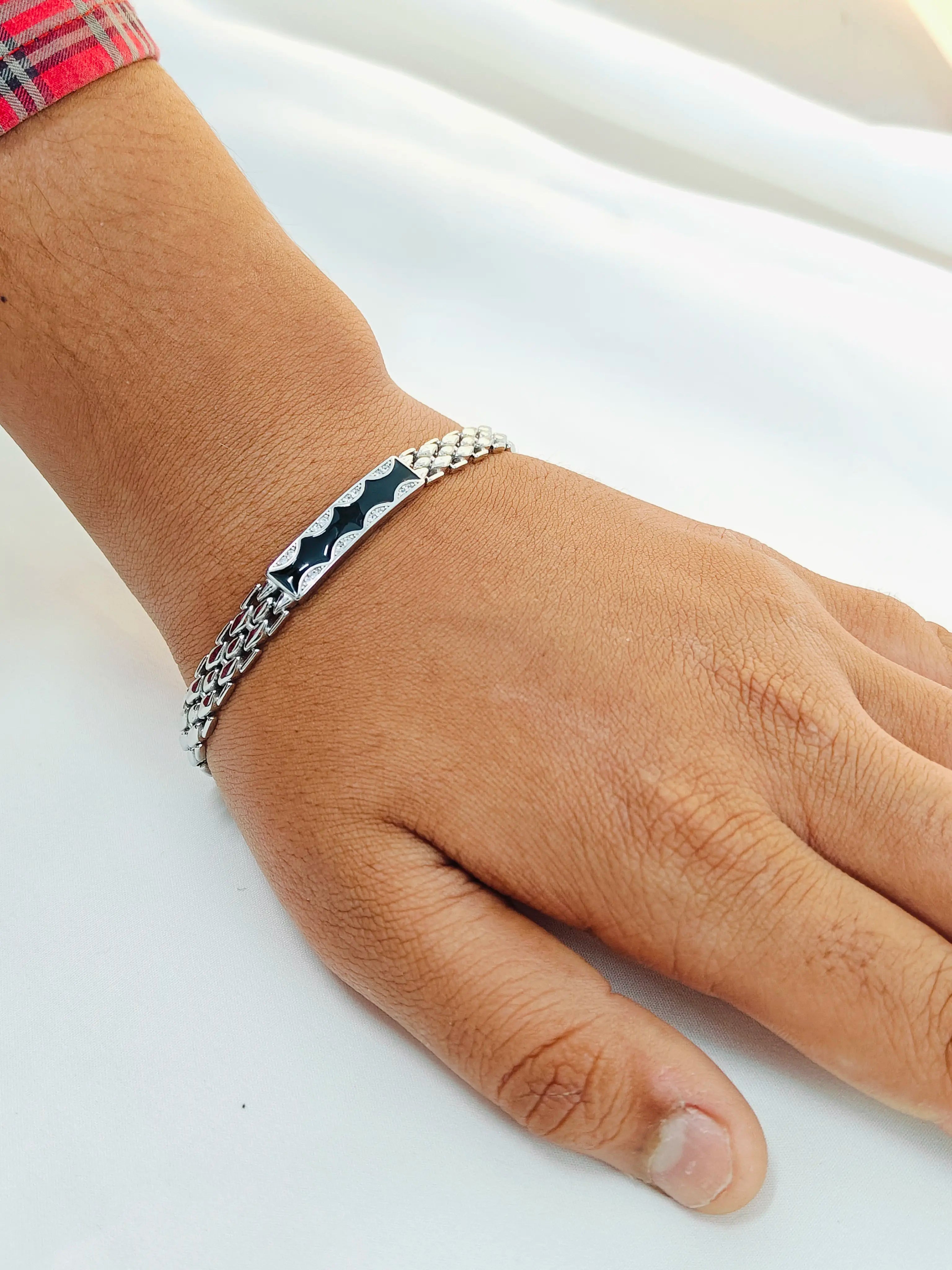Hand wearing a silver bracelet on a white background