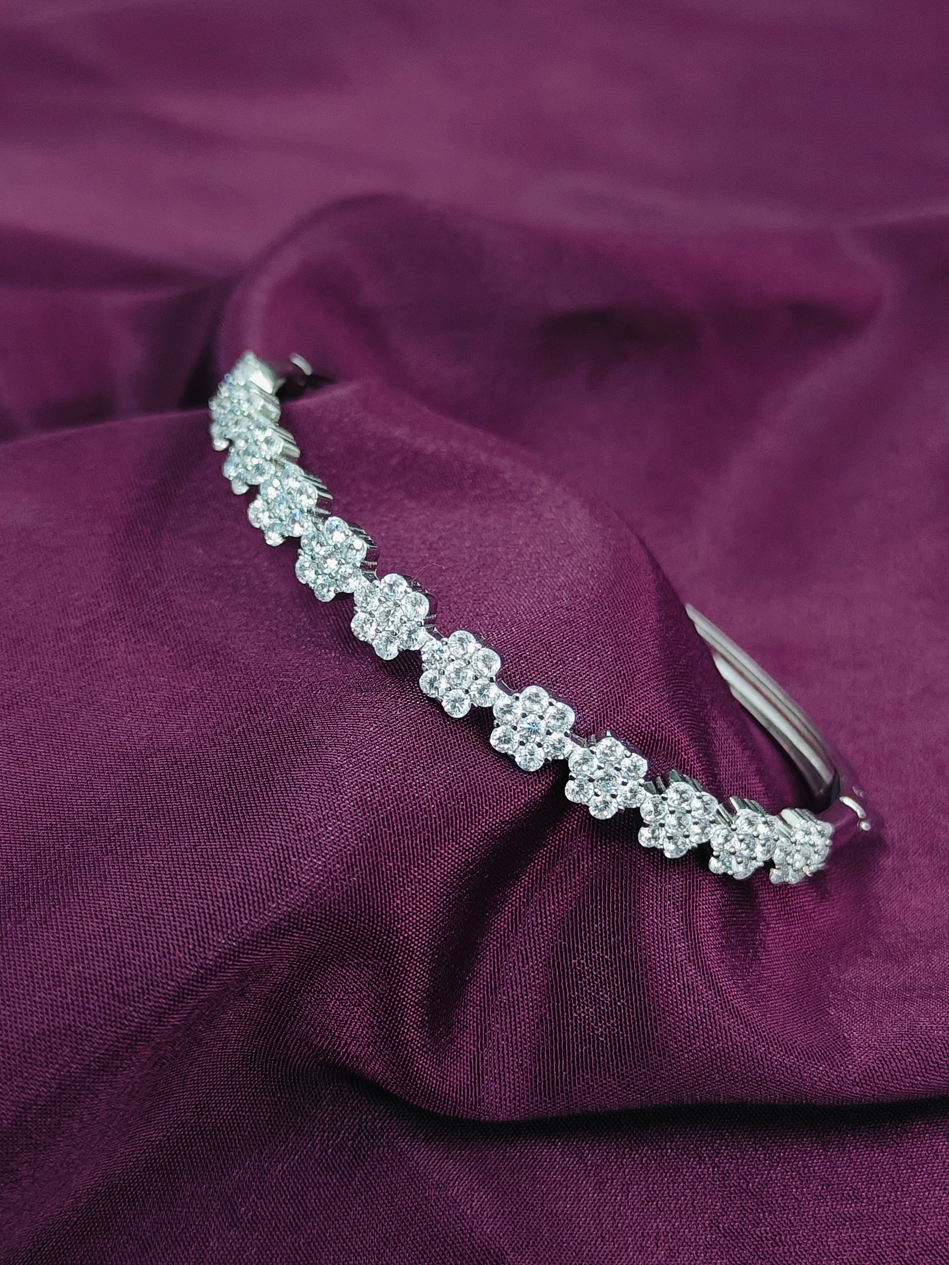 Silver headband with floral design on a purple fabric background