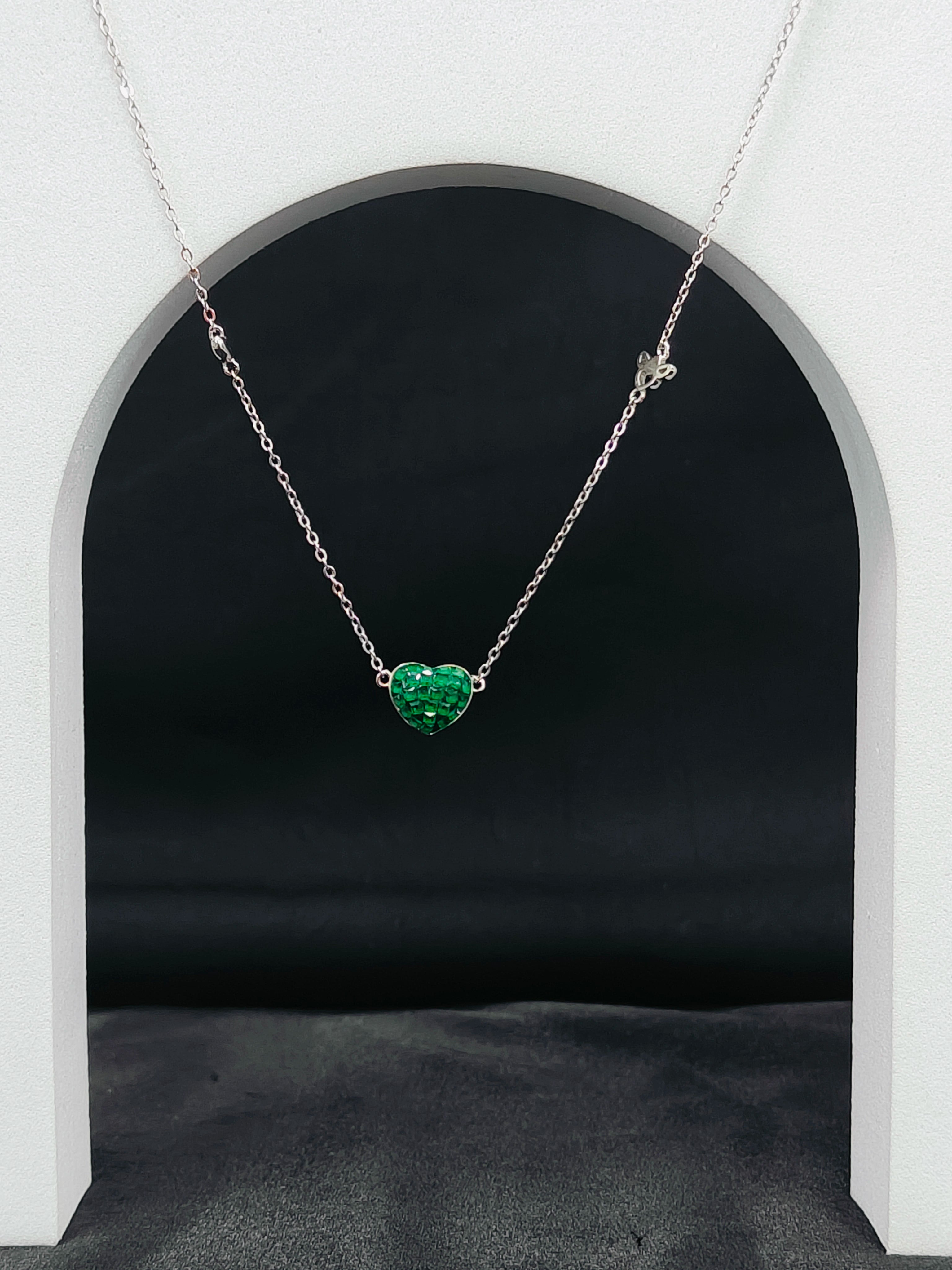 Necklace with a green heart-shaped pendant on a dark background