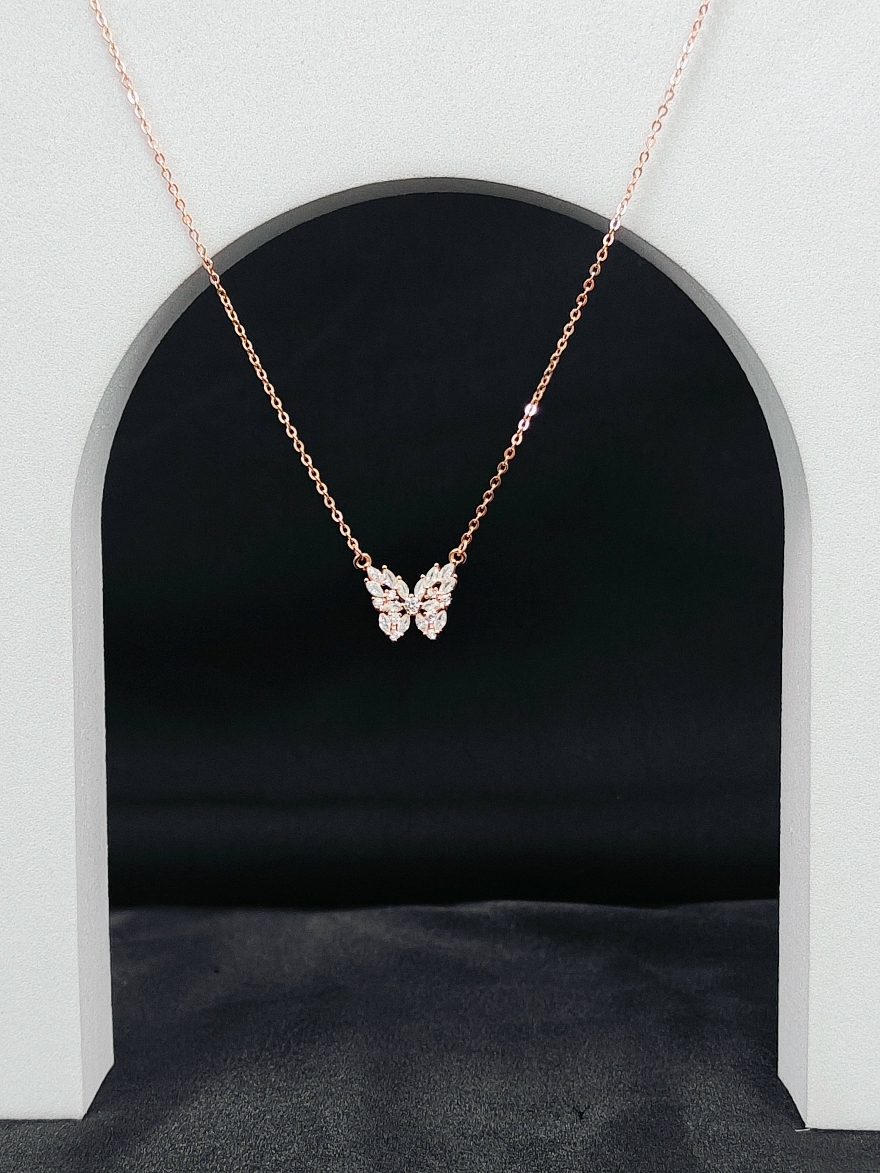 Butterfly necklace on a black background with a white arch