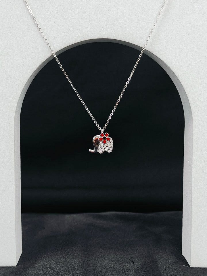Necklace with a pendant shaped like a cat in a red bow tie against a black background