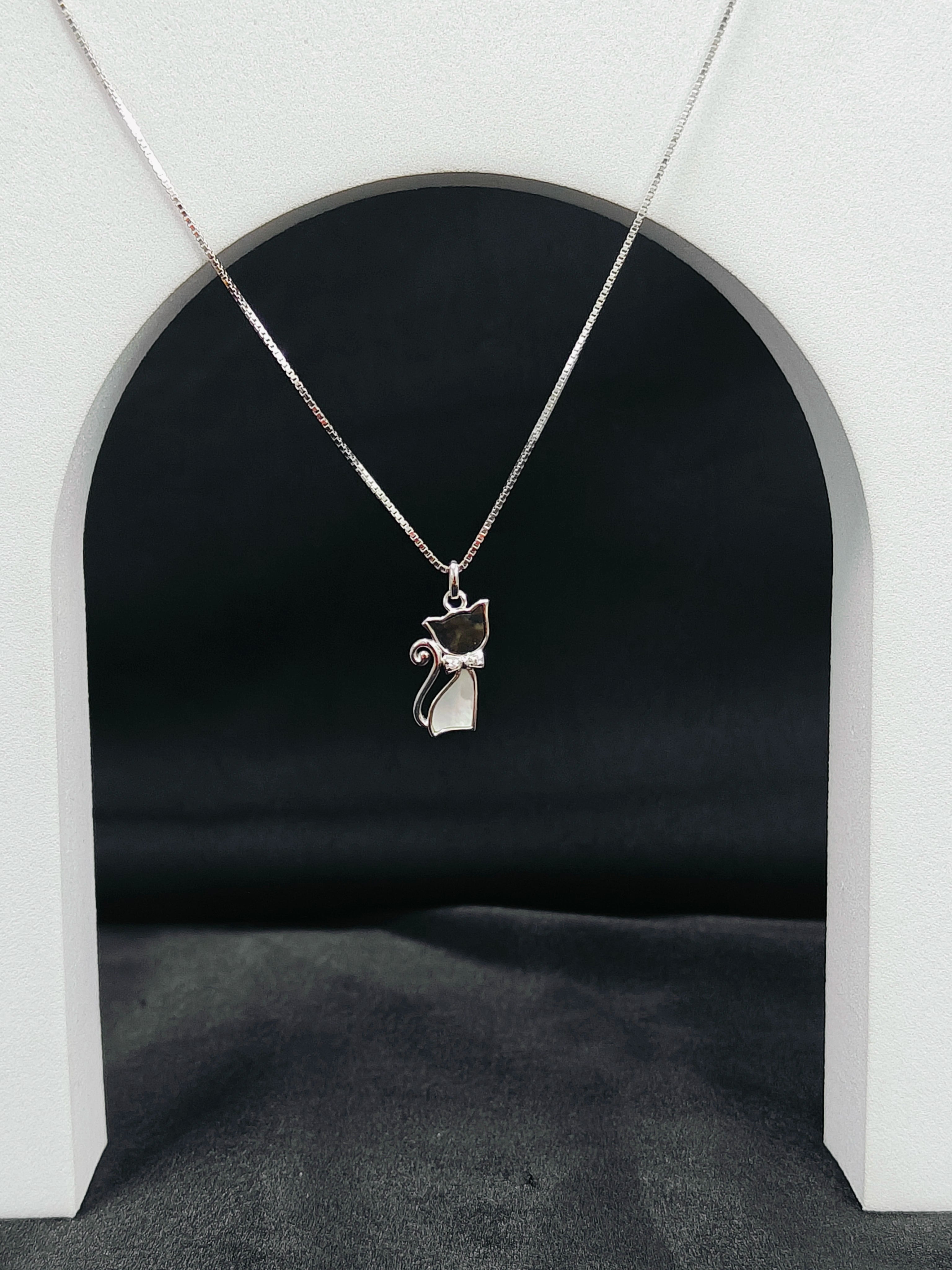 Silver cat-shaped pendant necklace on a dark background